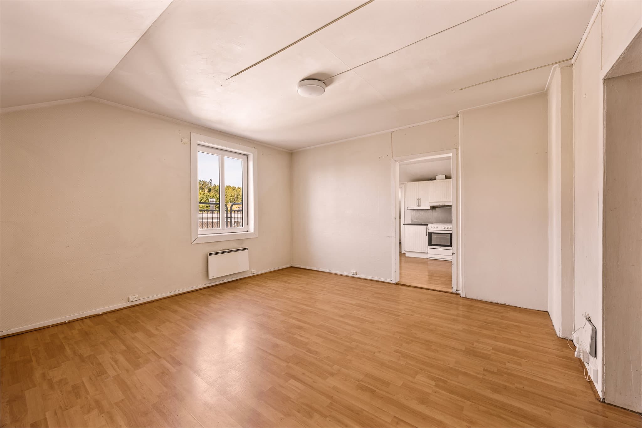 Stuen har laminatgulv, malte veggflater med strietapet og takflater med malte plater og panel.