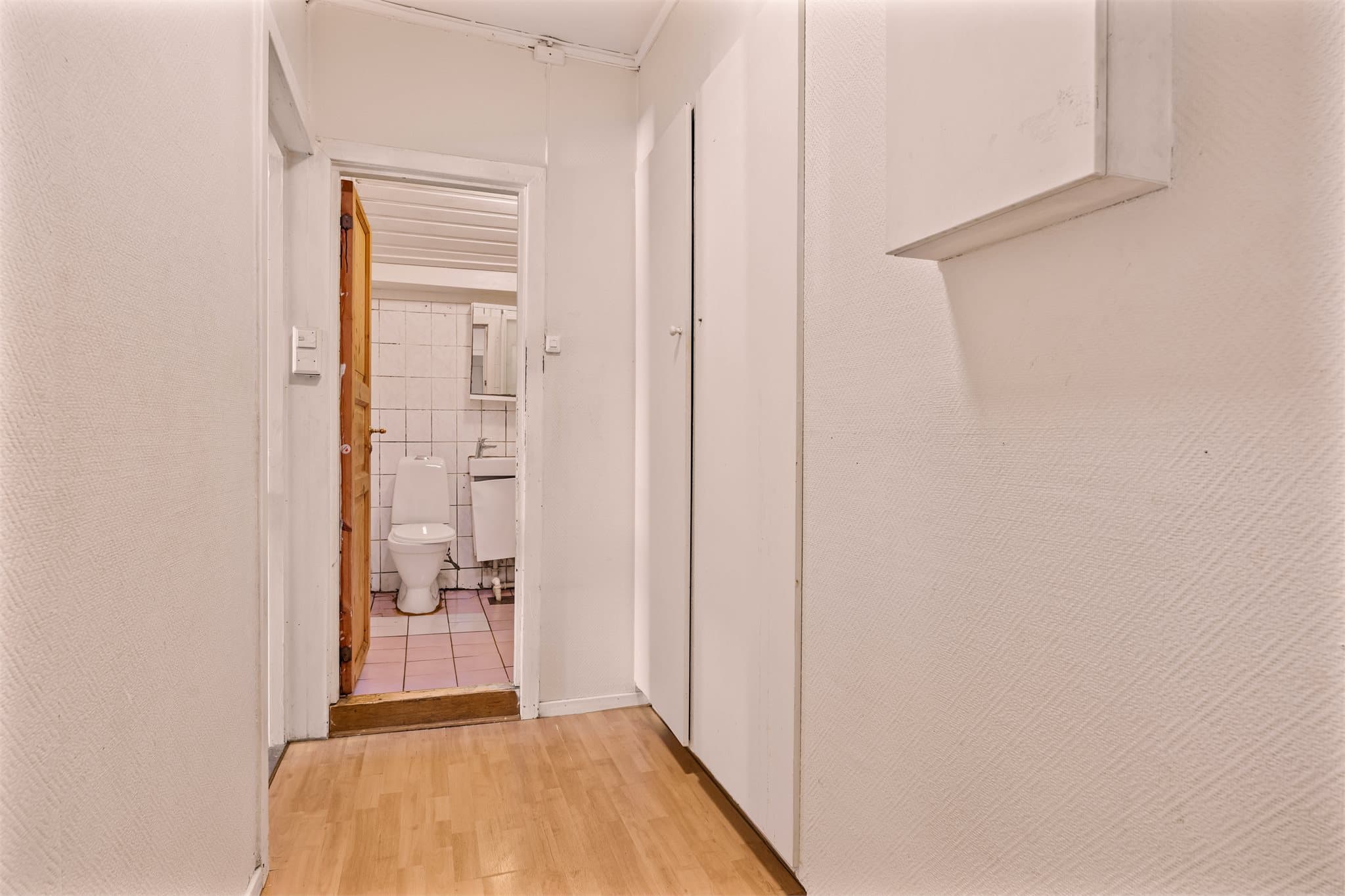 Gulvet er belagt med laminat, og herfra er det videre adkomst til boligens øvrige rom.