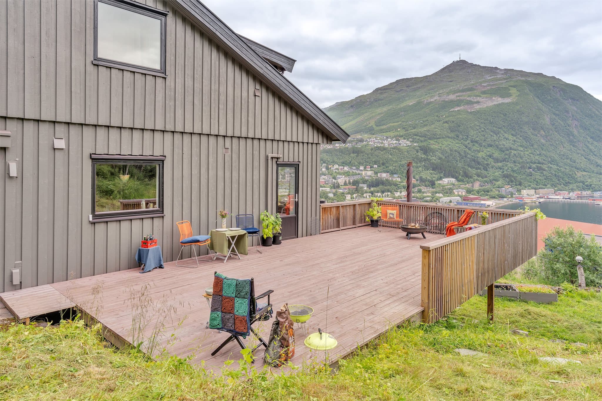 Stor veranda i trykkimpregnerte materialer med vidstrakt utsikt mot Narvikfjellet.