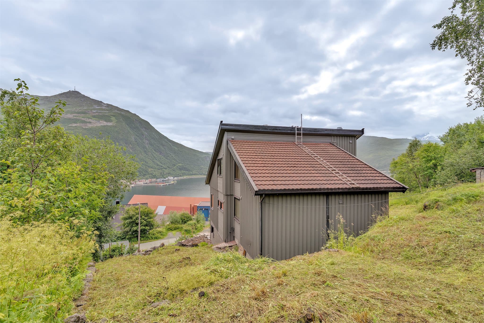Boligen har pulttak tekket med steinbelagte stålplater og stående trekledning.