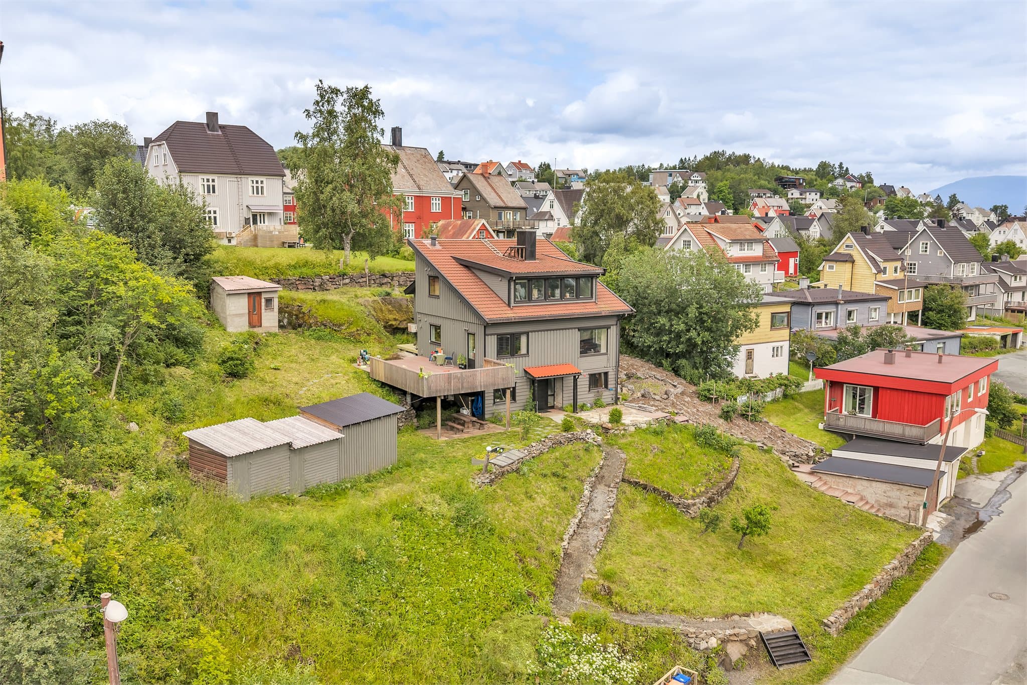 Eiendommen har en romslig tomt på ca. 882 m² opparbeidet med plen, trapper i terrenget og garasje.