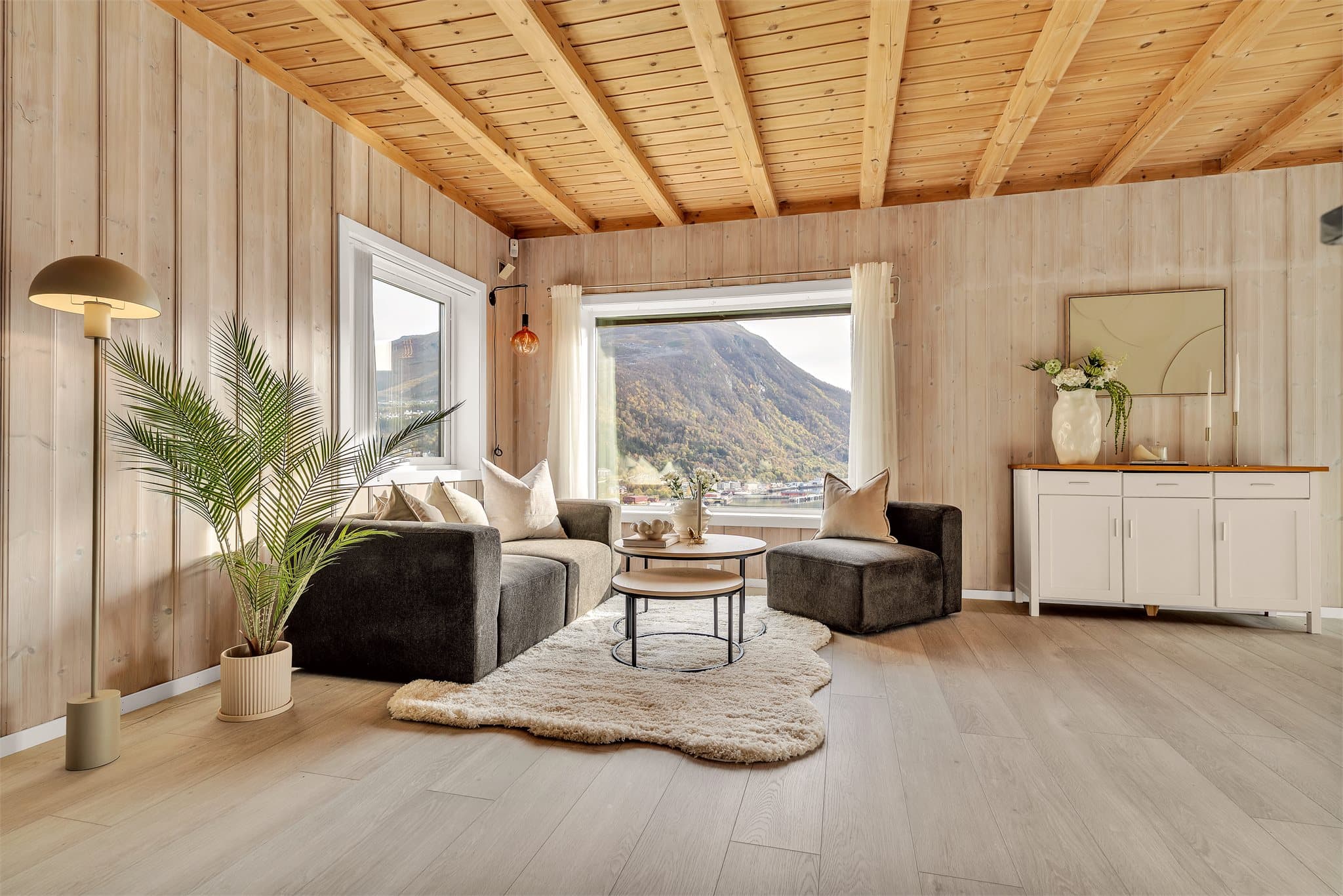 Stort panoramavindu rammer inn utsikten mot fjorden og de omkringliggende fjellene.