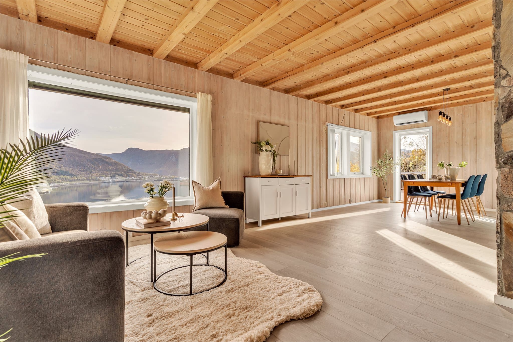 Stuen har store vindusflater mot fjorden og direkte utgang til en romslig veranda. Styling: Fjelldal Interior