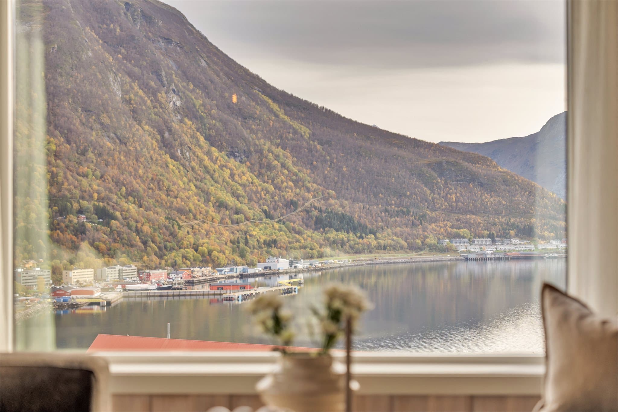 Utsikt mot fjorden og fjellandskapet fra stuevinduet.
