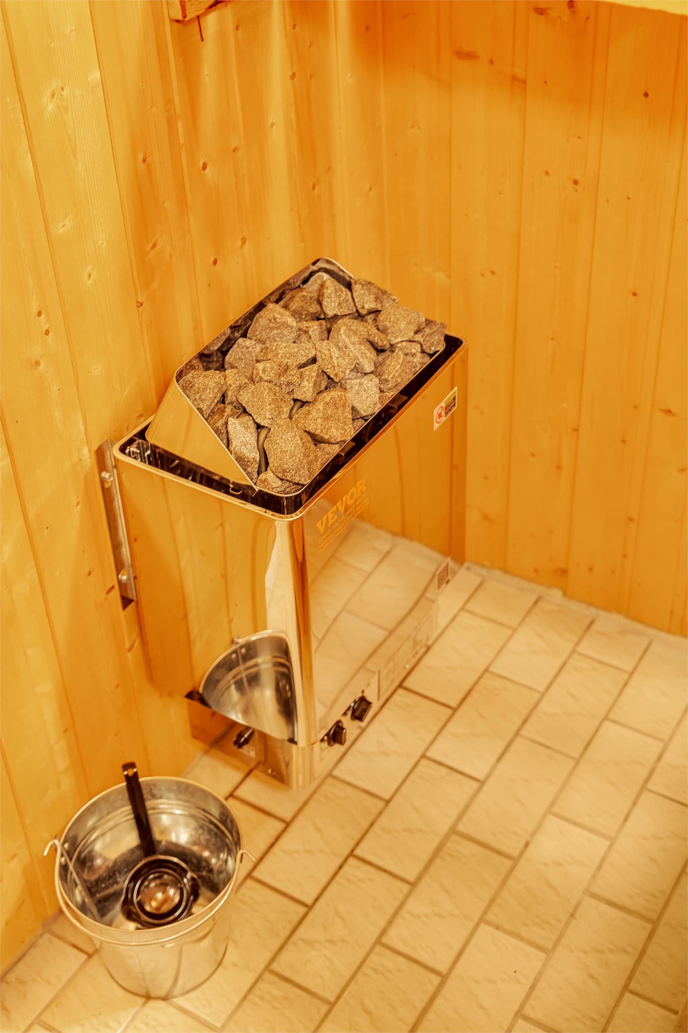 Elektrisk badstuovn montert på trepanelkledd vegg.