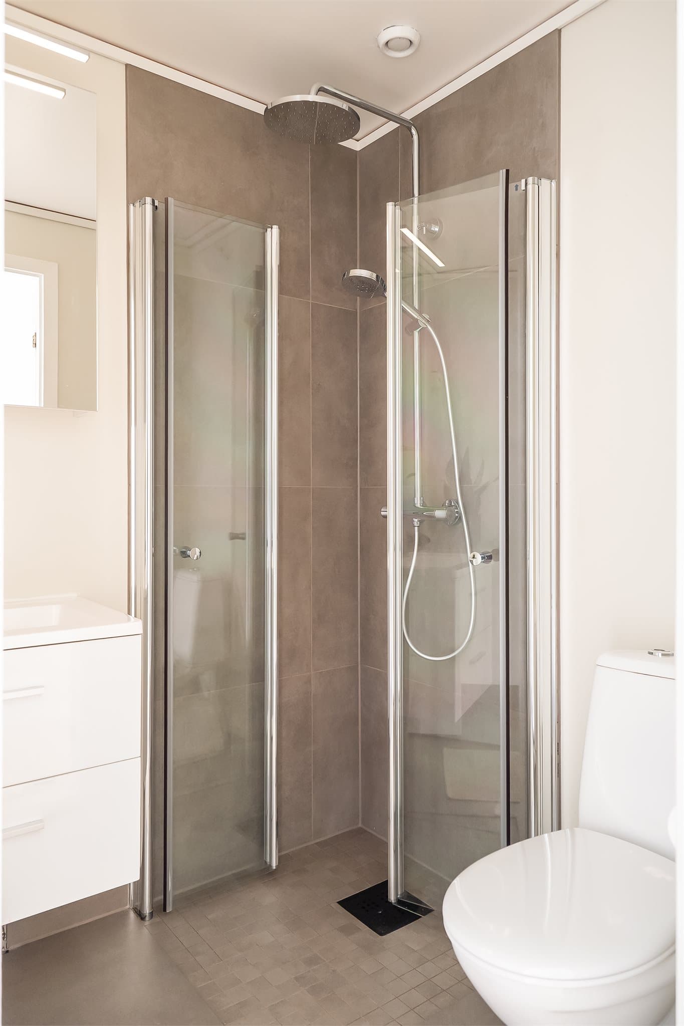 Dusjen har regndusj og innfellbare dusjdører.