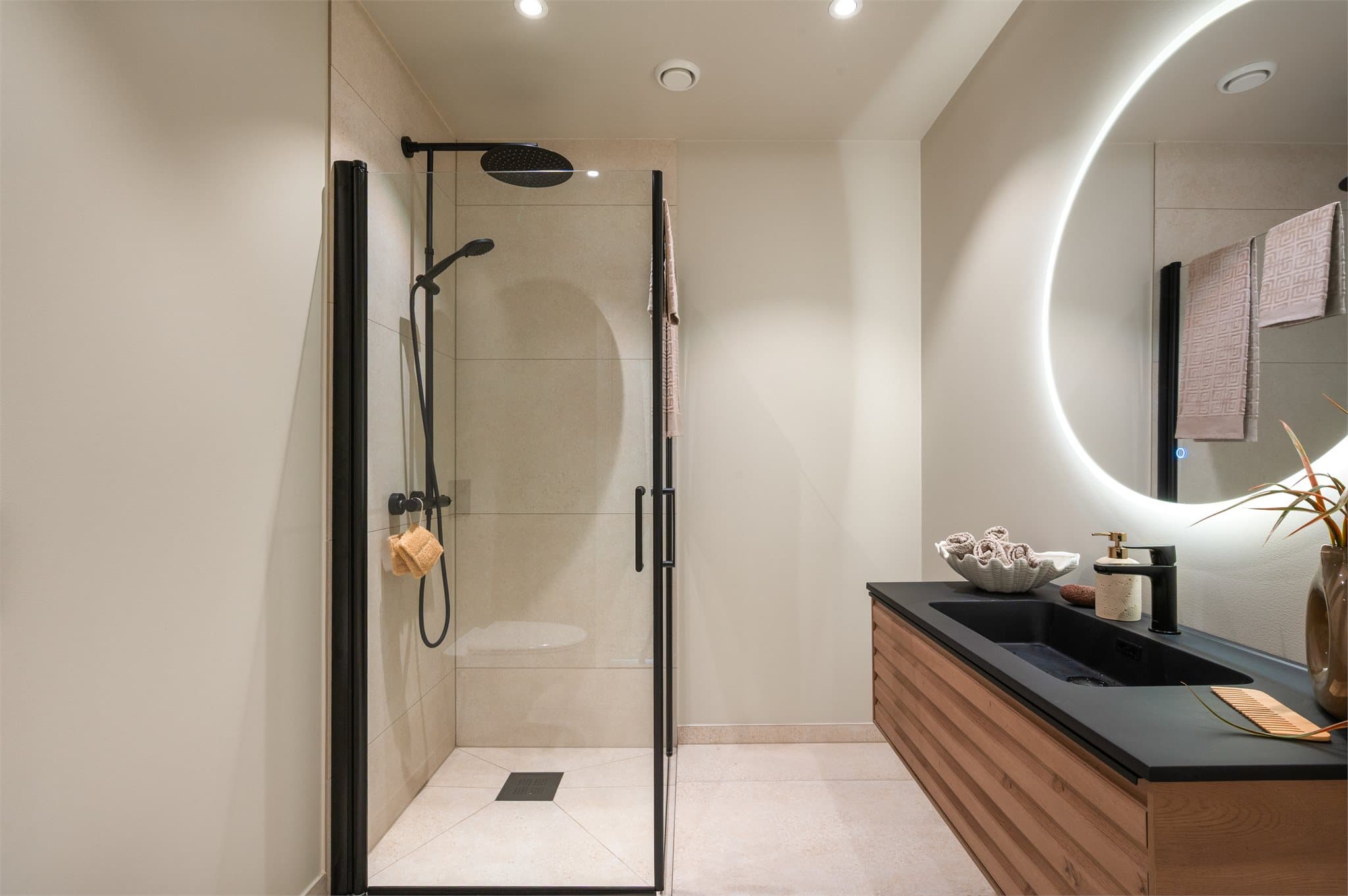 - Badet er innredet med speil m/ belysning, vegghengt toalett, dusj og benkeskap m/ servant -