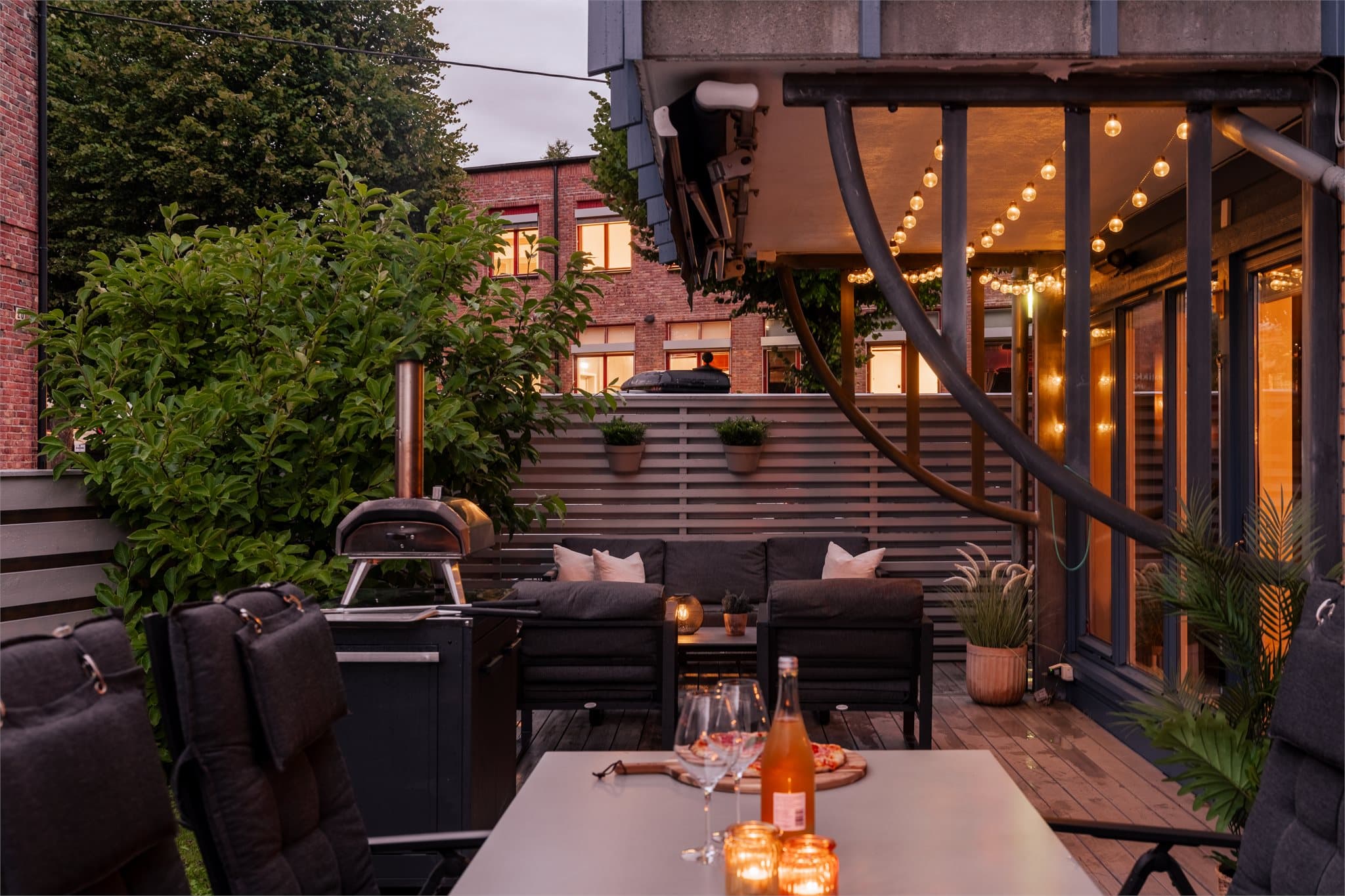 Terrassen er tilrettelagt for det gode uteliv med komfortabel lounge, spiseplass og pizzaovn.
