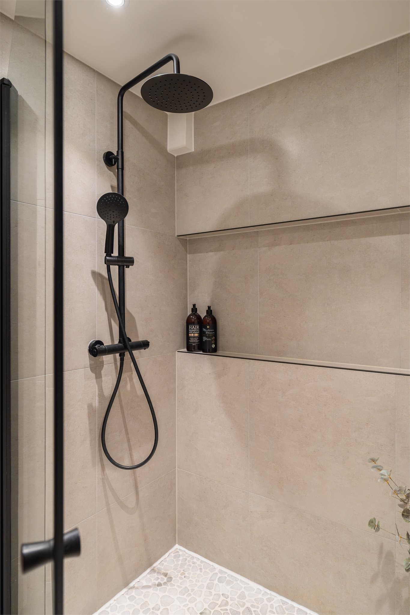 Her har du en stor dusj med integrert plass til såper og lignende- stilfullt og praktisk