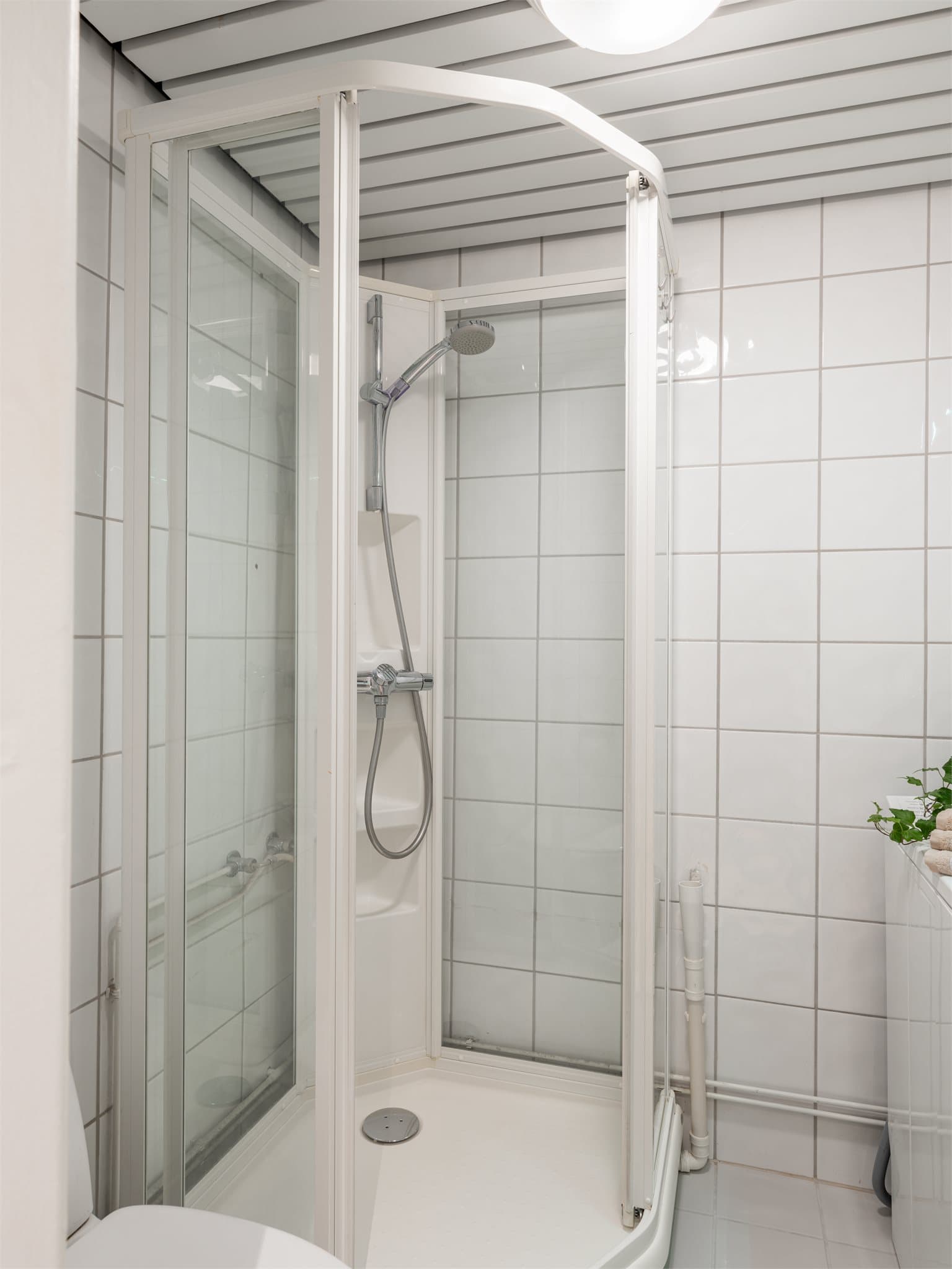 Badet har dusjkabinett og elektriske varmekabler i det flislagte gulvet.