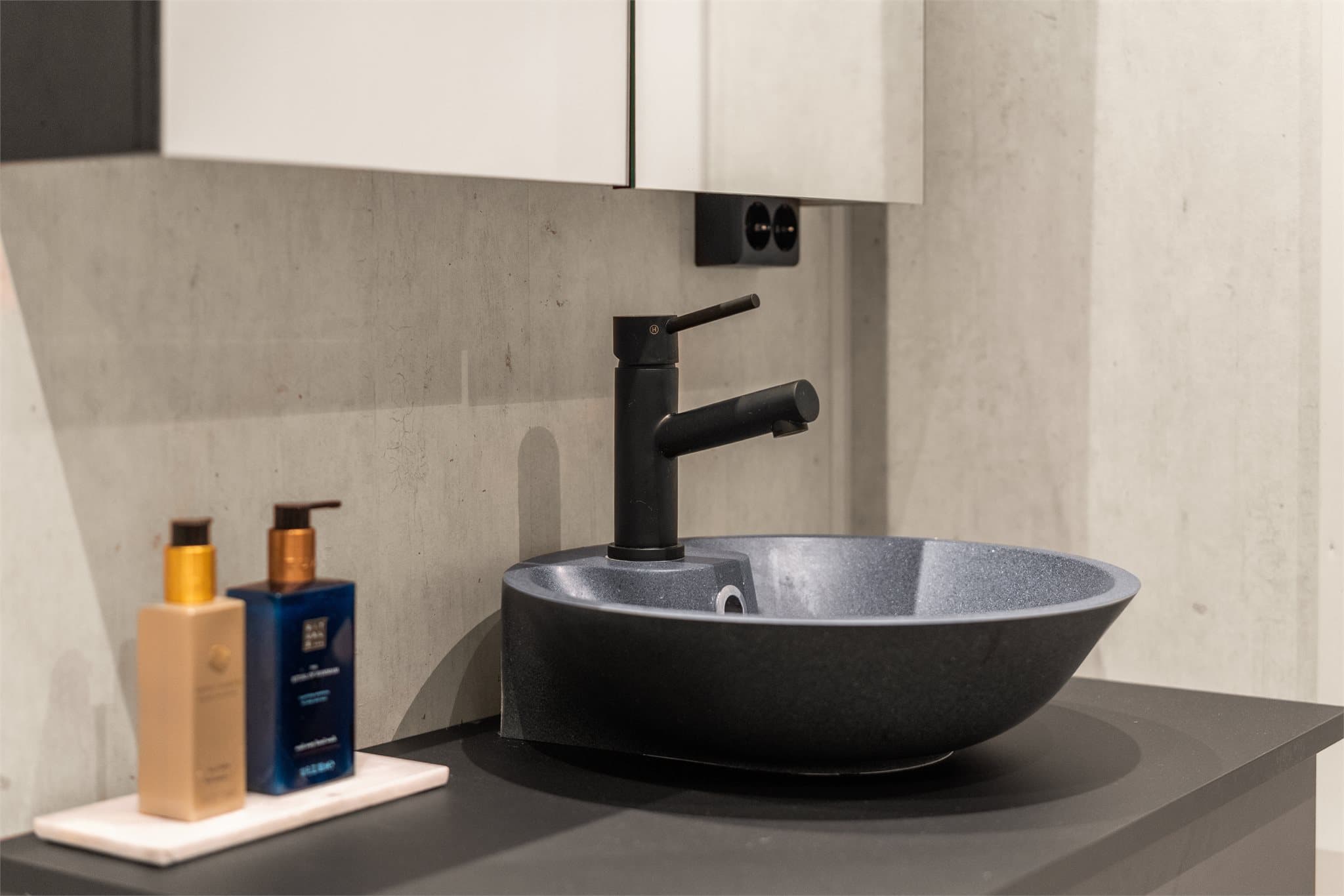 Innredningen består av bolleservant på underskap, speilskap, vegghengt toalett og dusjhjørne.