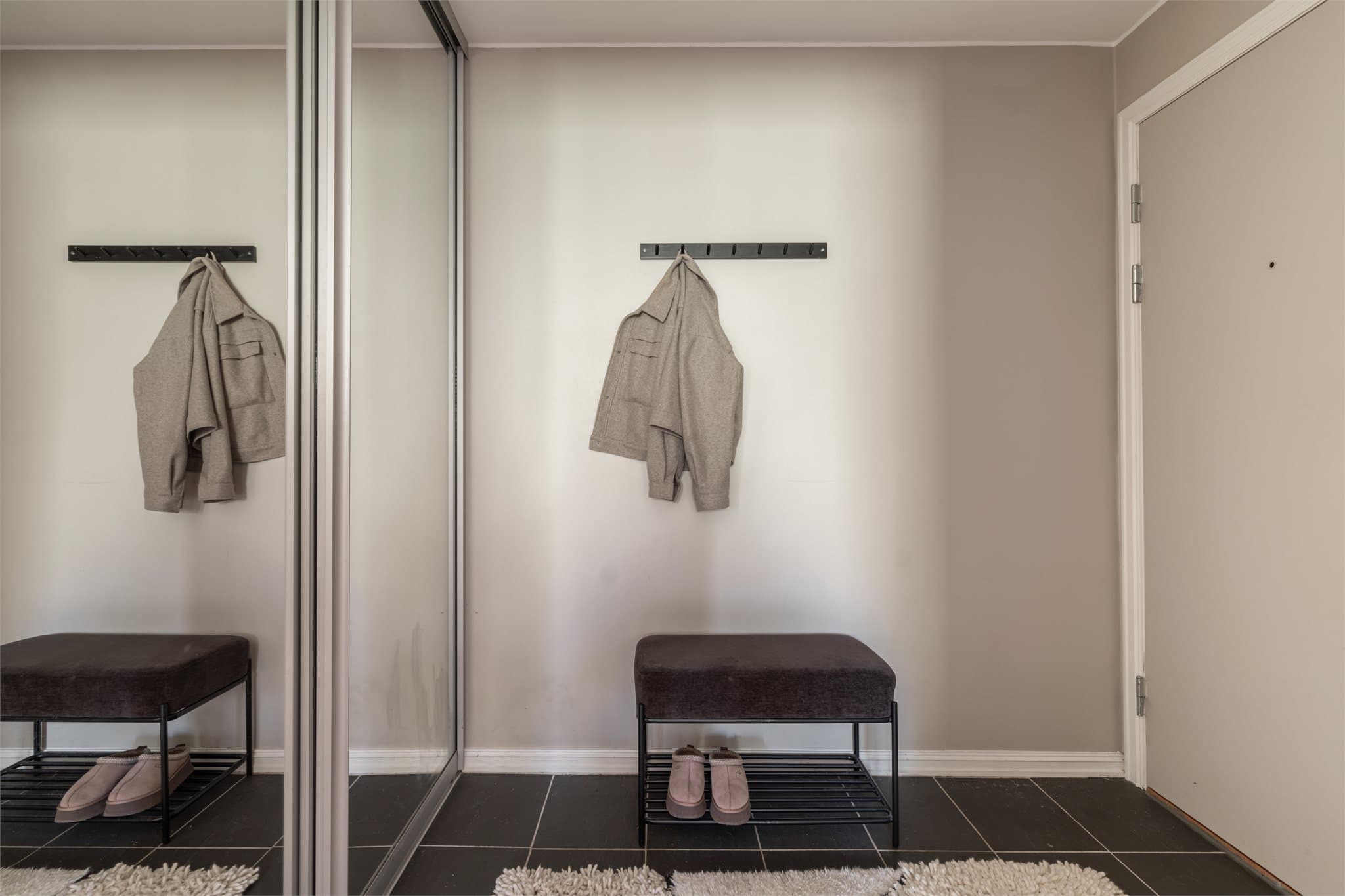 Romslig entré med flislagt gulv og god plass til oppbevaring i skyvedørsgarderobe.