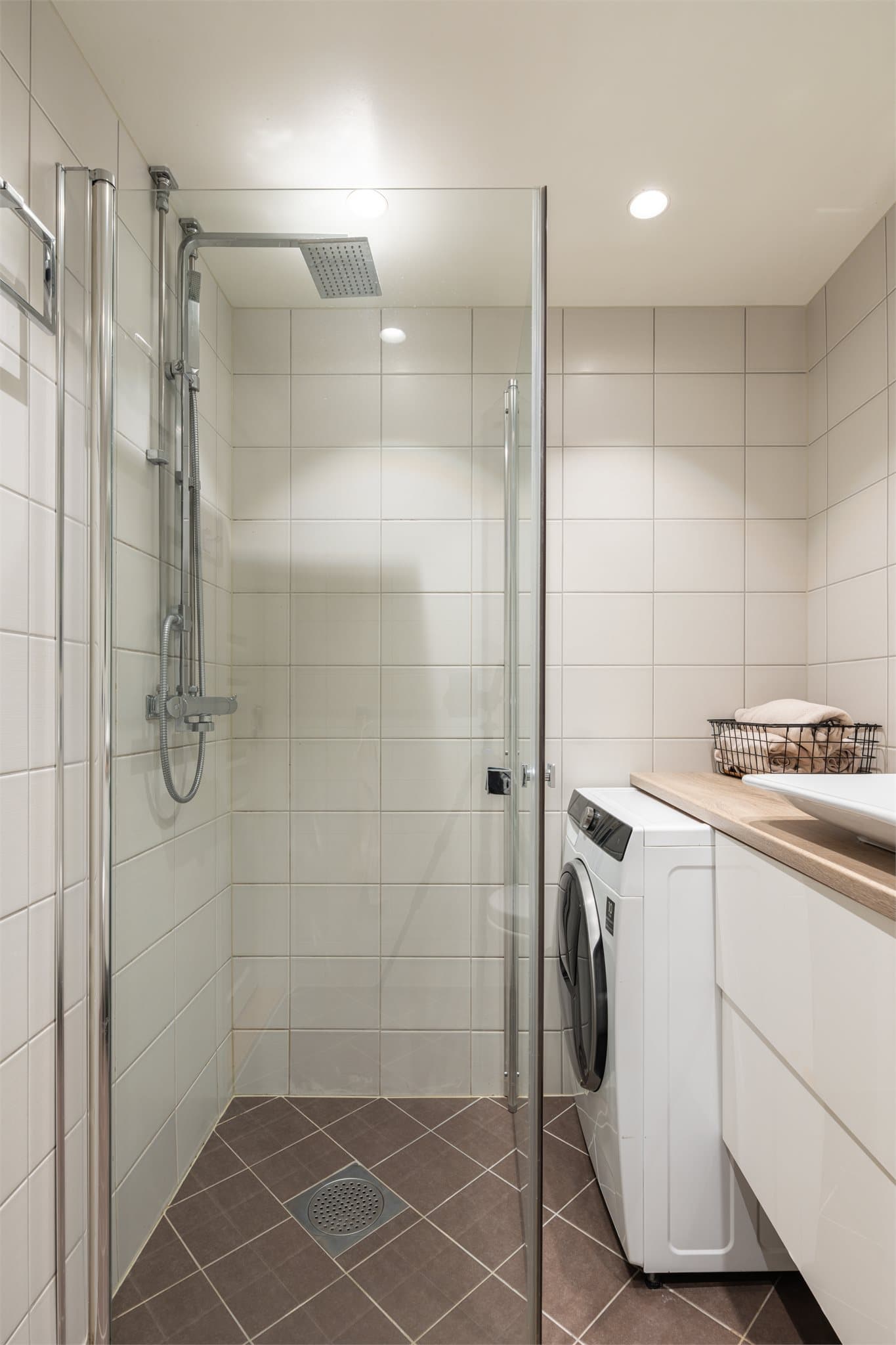 Badet er innredet med vegghengt toalett, servant med underskap og dusjhjørne med svingbare glassdører. Det er opplegg for vaskemaskin.