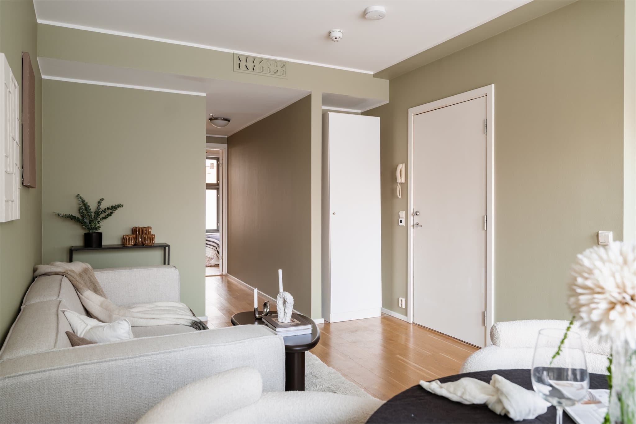 Velkommen inn i en lys entré med parkett på gulvet og sikringsskap.