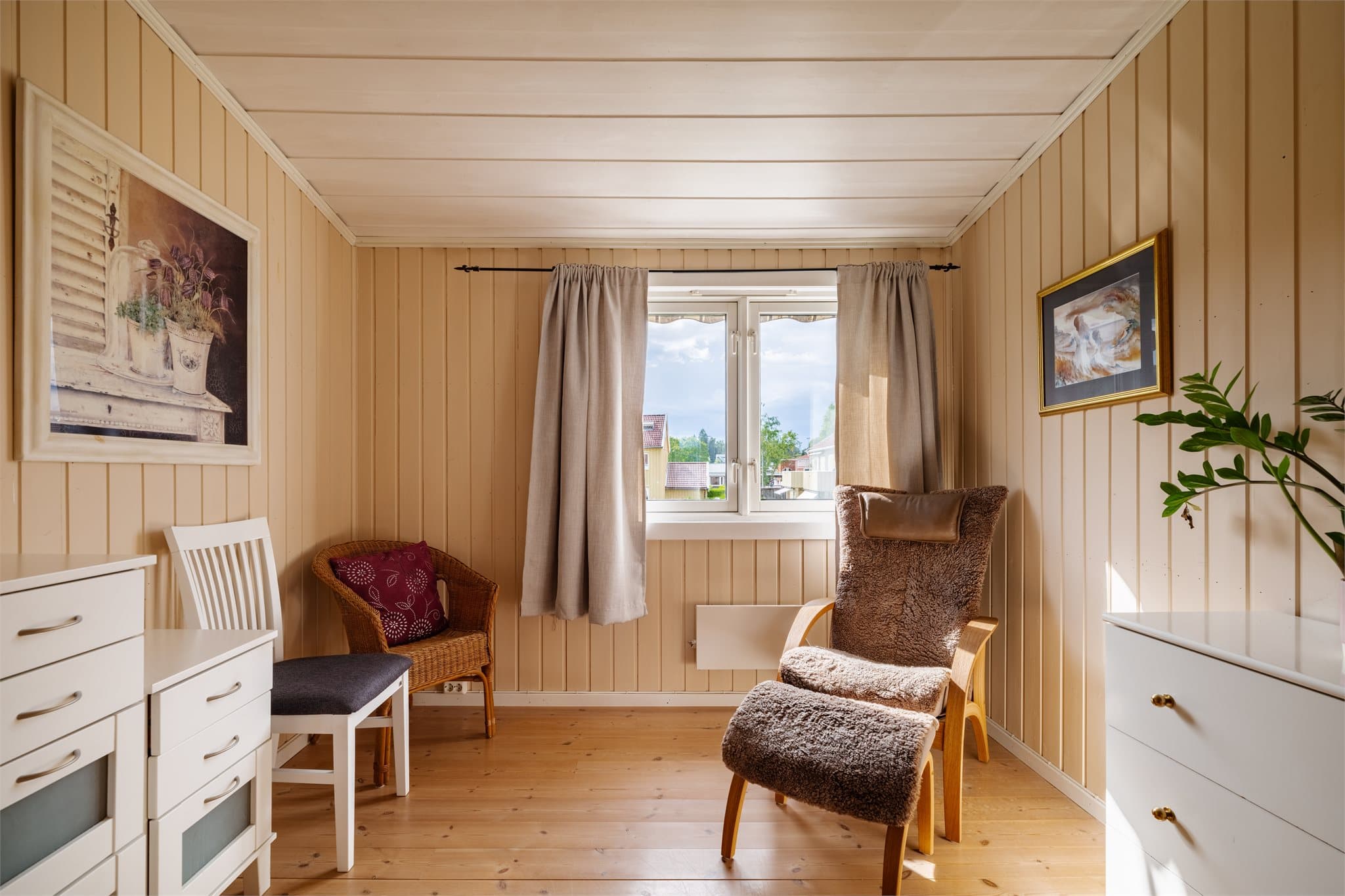 Soverom med overflater av trepanel og furugulv.