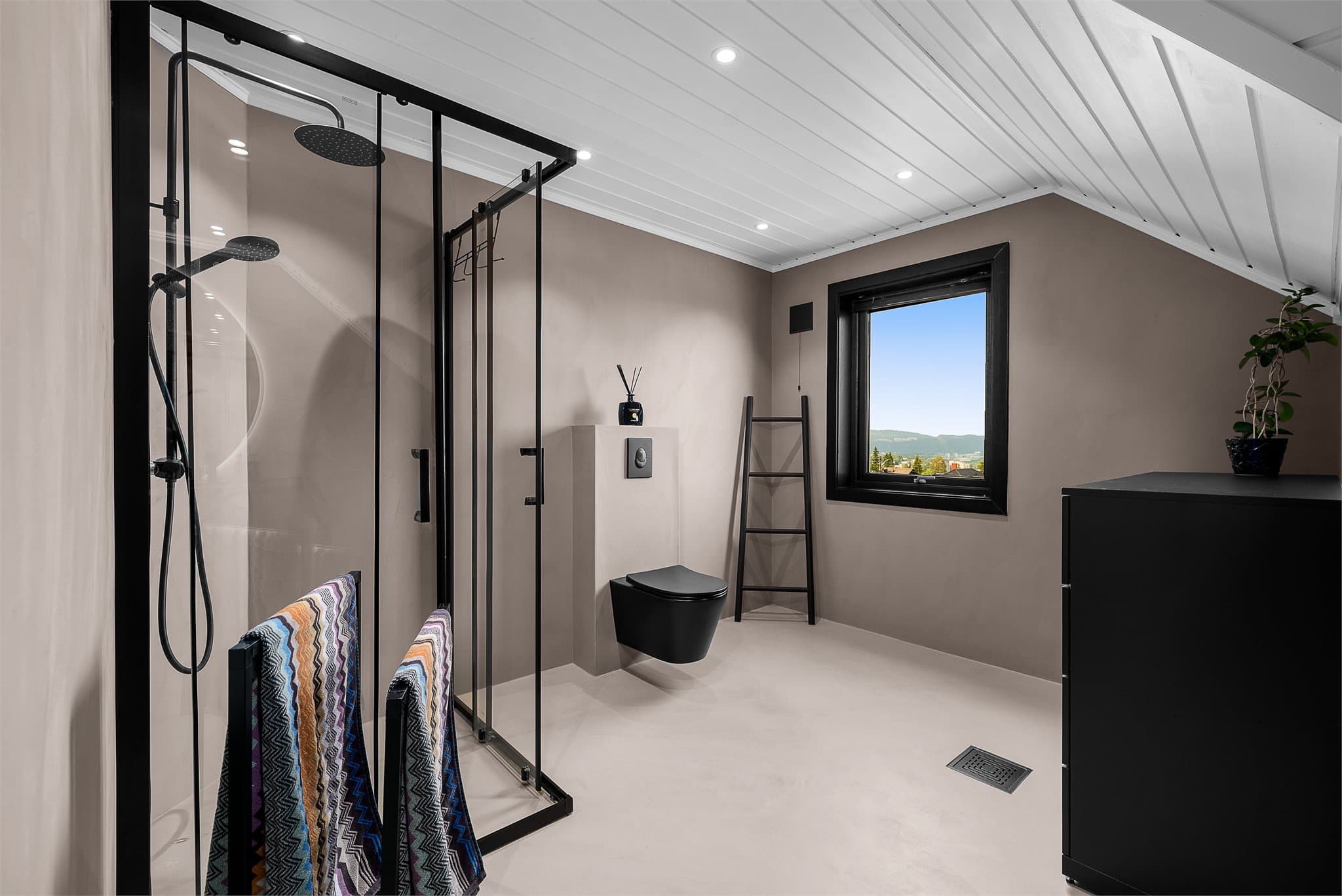 Vegghengt klosett, romslig dusjhjørne med regnfalls dusj og fin utsikt.