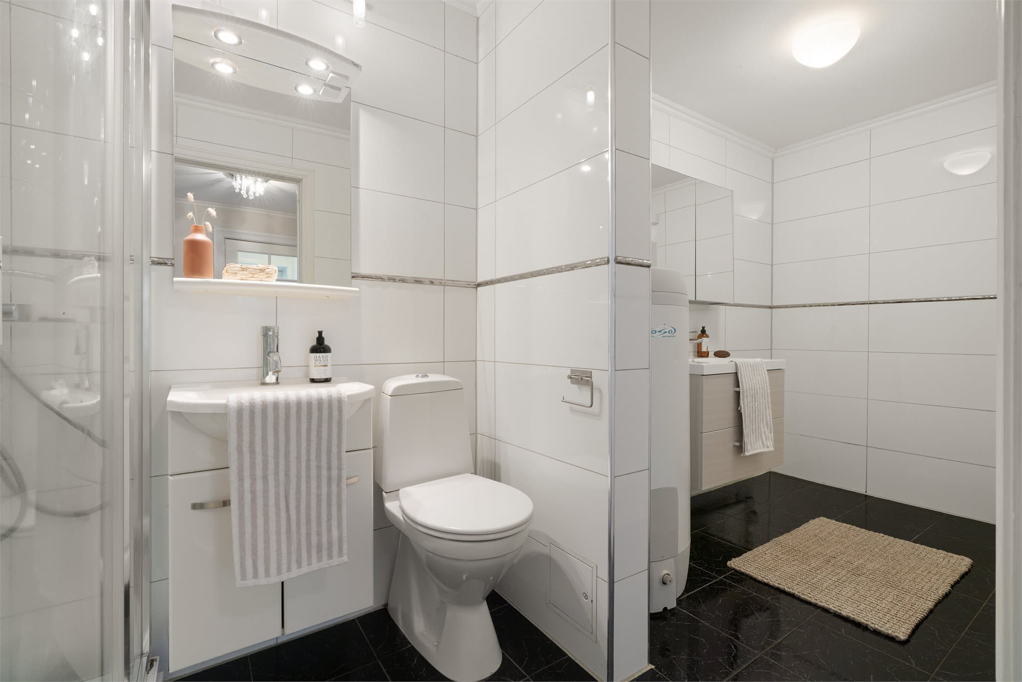 - Badet er innredet med dusjkabinett, to heldekkende servanter, speilskap, toalett, varmtvannsbereder og opplegg for vaskemaskin -