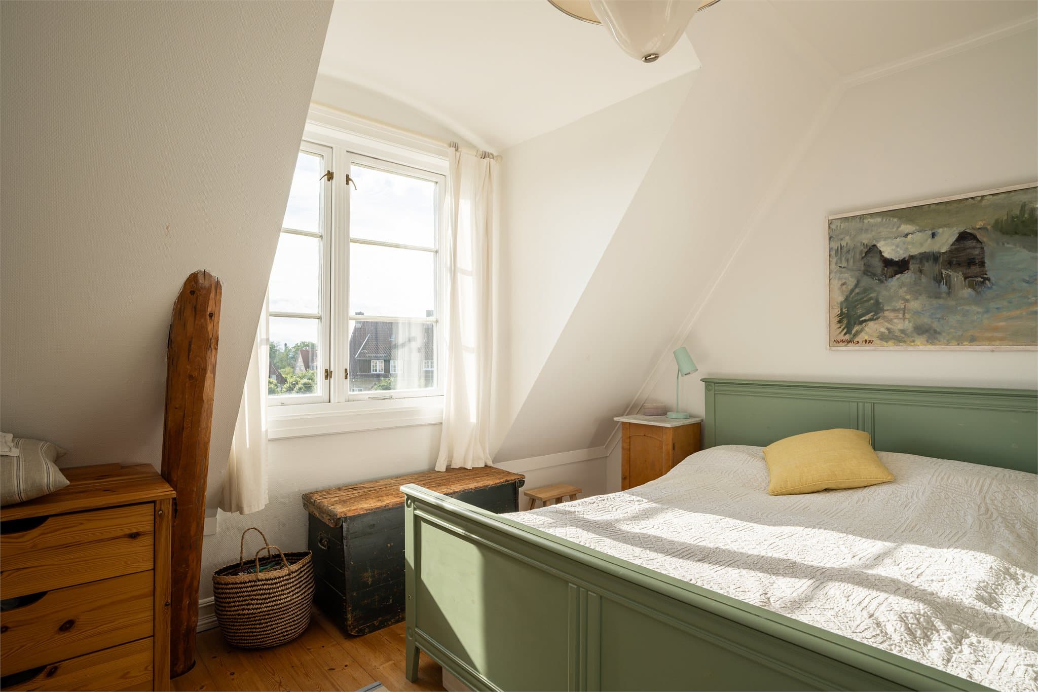 De arkitektoniske detaljene med skråtak og heltre vindu tilfører rommet særpreg og et klassisk uttrykk.