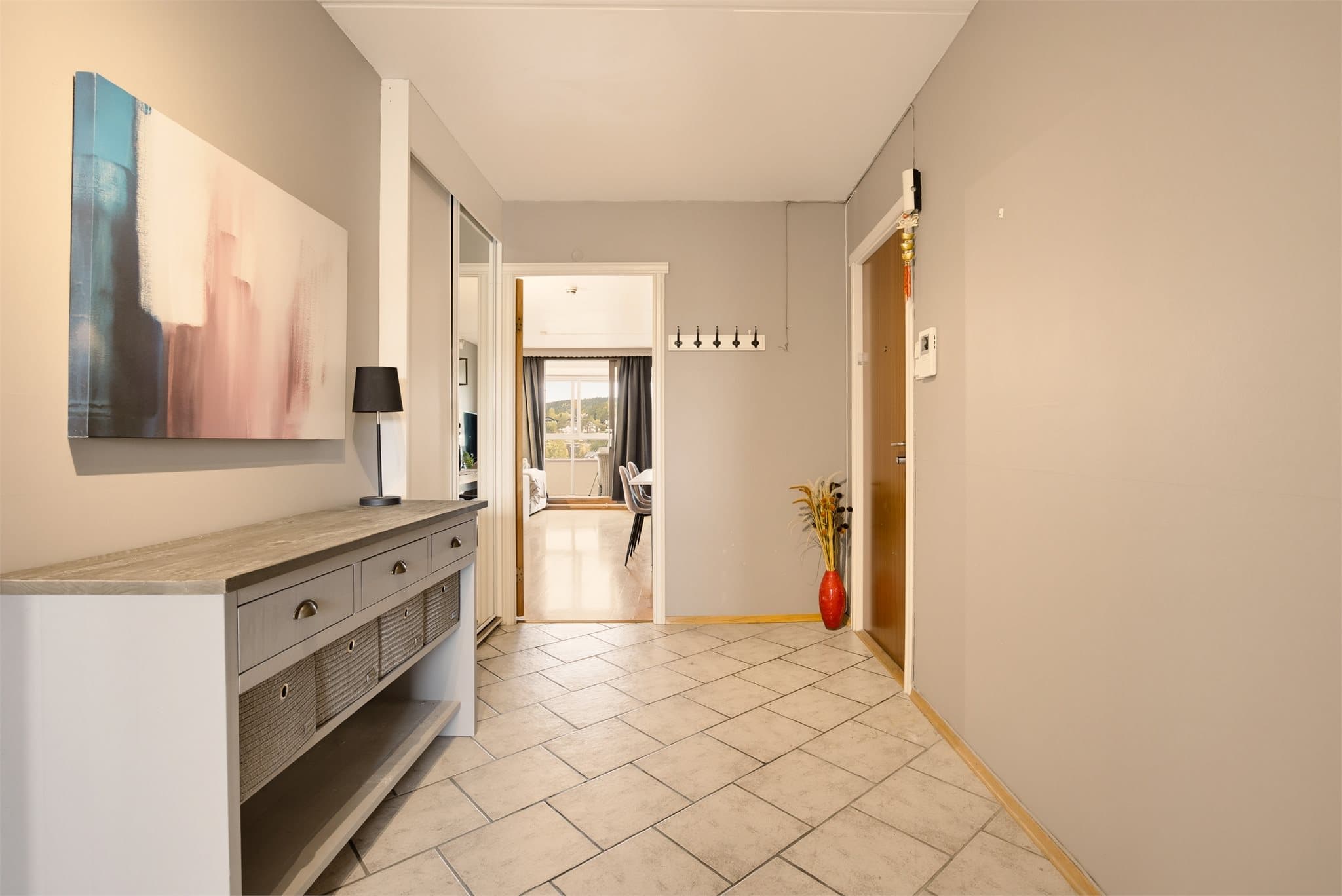 Det er god plass til å henge fra seg yttertøy i praktisk skyvedørsgarderobe med speilfronter.