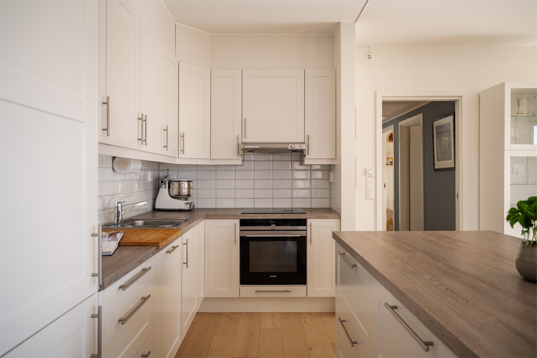 Kjøkkeninnredning med profilerte fronter og laminatbenkeplate med nedfelt vask.