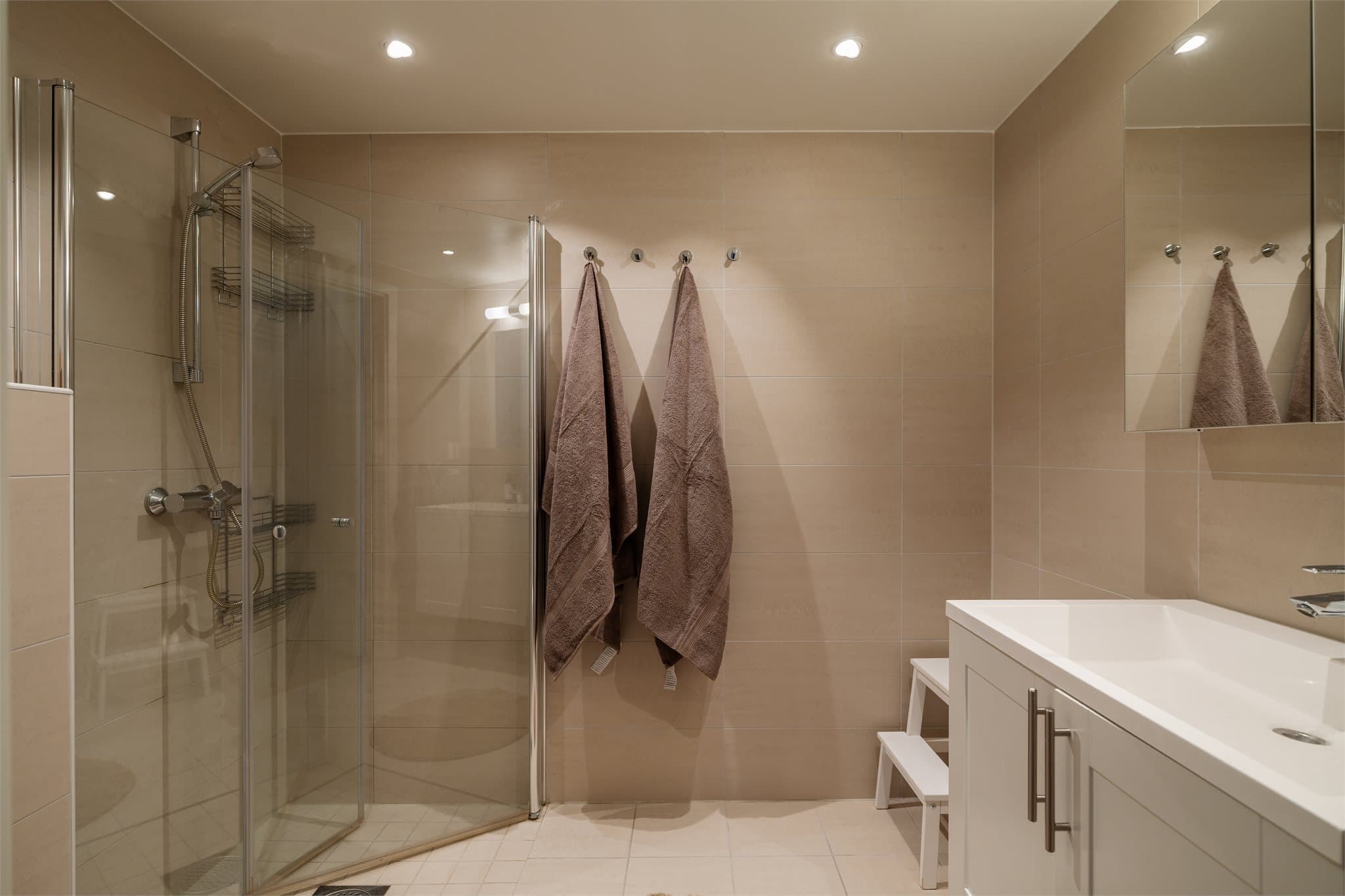 Badet nås fra hovedsoverommet og er helfliset og utstyrt med vannbåren gulvvarme, downlights i taket og dusjhjørne med svingbare glassdører.