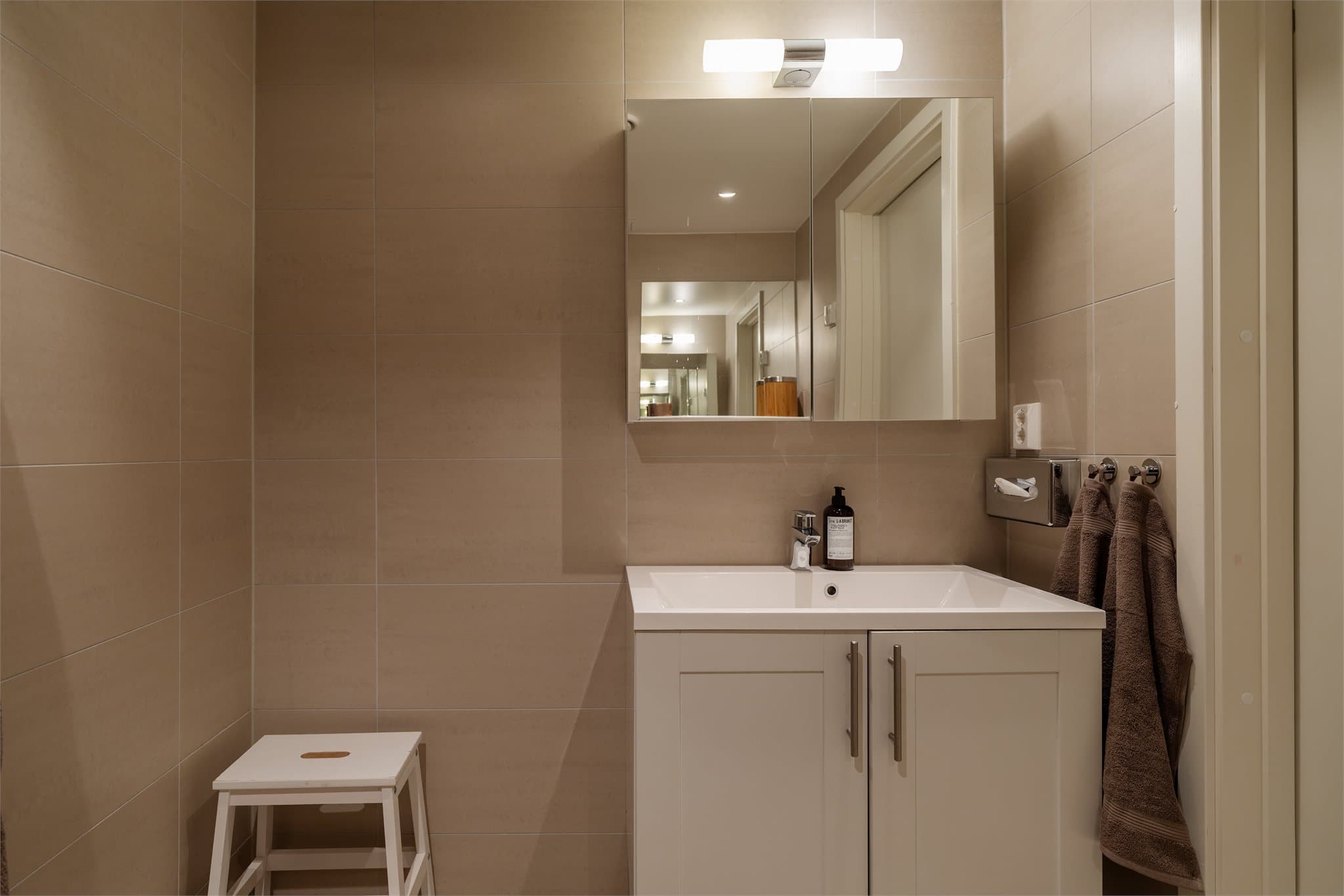 Servant nedfelt i innredning og et praktisk speilskap med belysning og oppbevaringsplass.