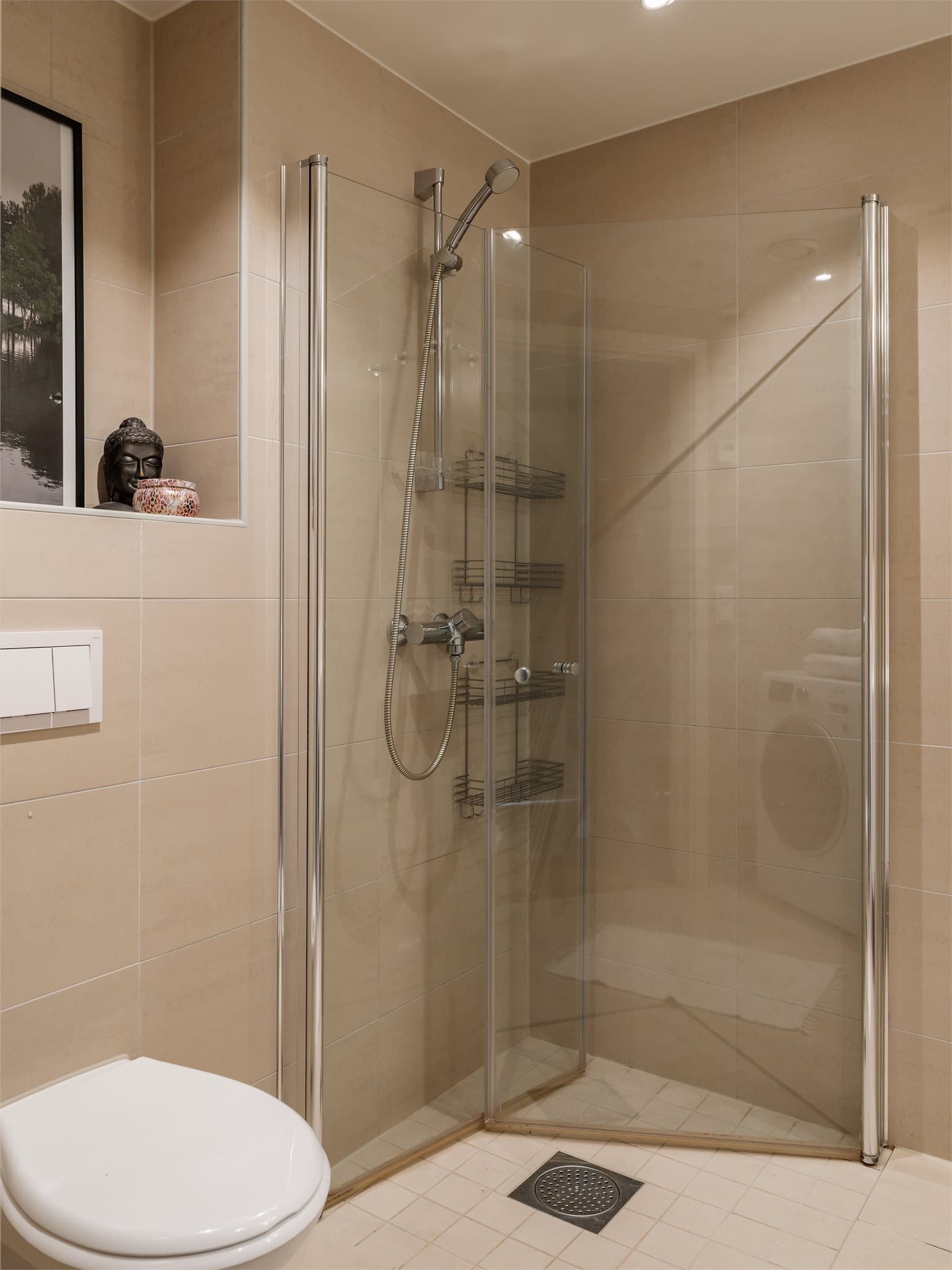 Også dette badet har vegghengt toalett og et dusjhjørne med innfellbare glassdører.