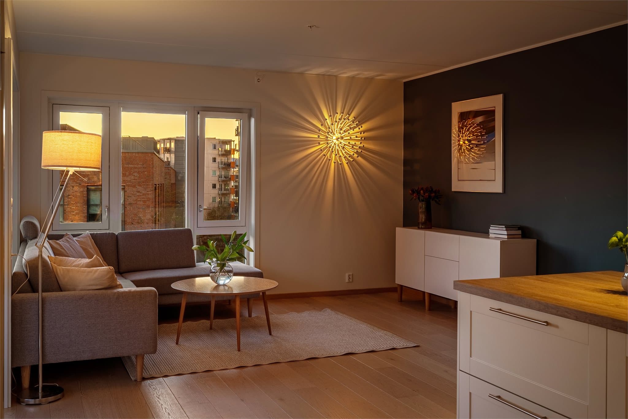 Stemningsfull belysning skaper en lun atmosfære i stuen på kveldstid.