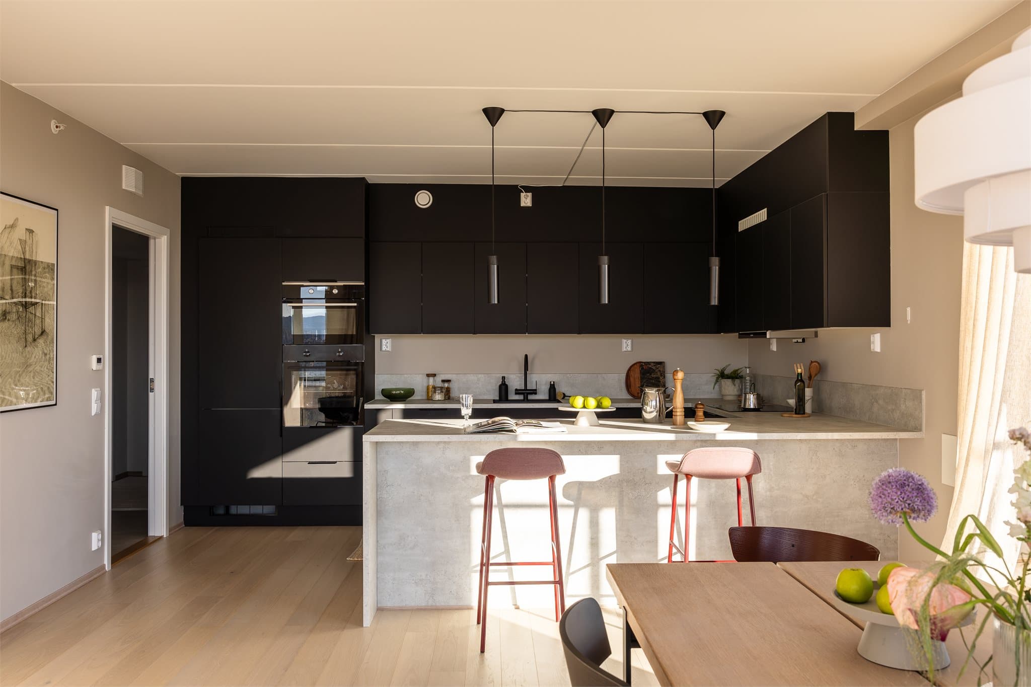 Kjøkkenet går i en hestesko med barløsning som gir et perfekt sted å servere mat på, samtidig som at den deler opp rommet i flere deler.