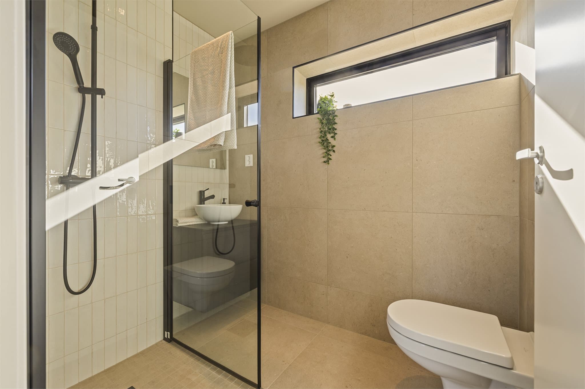 Badet i underetasjen har et strammere uttrykk med sorte armaturer og detaljer.