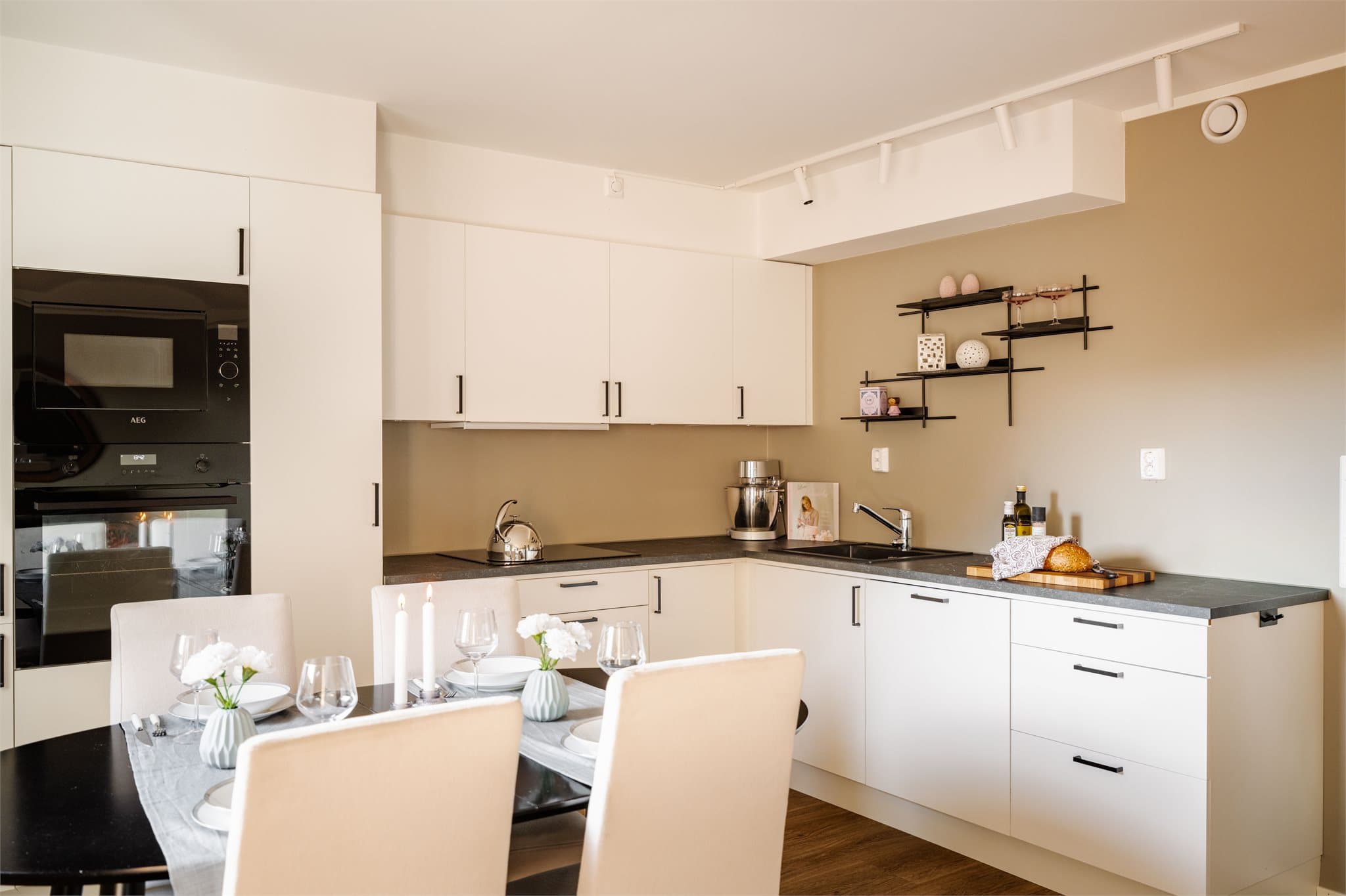 Kjøkkeninnredningen er fra Drømmekjøkkenet og har hvite, glatte fronter og laminat benkeplate.