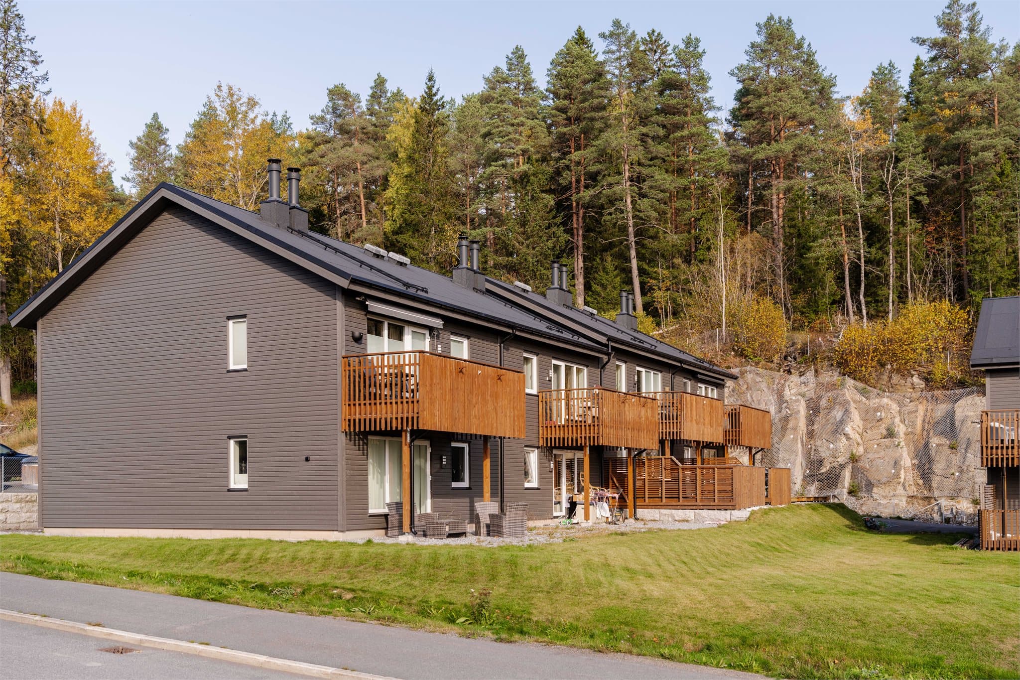 Tomten er noe kupert og er opparbeidet med plen, beplantning og lekeplass.