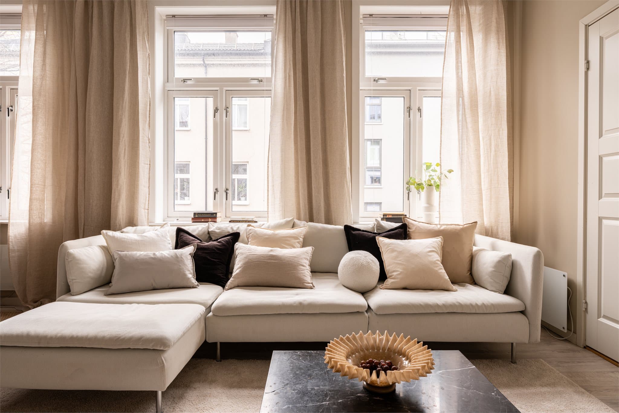 Klassiske vinduer med dype karmer slipper inn rikelig med dagslys og understreker bygårdens sjarm.