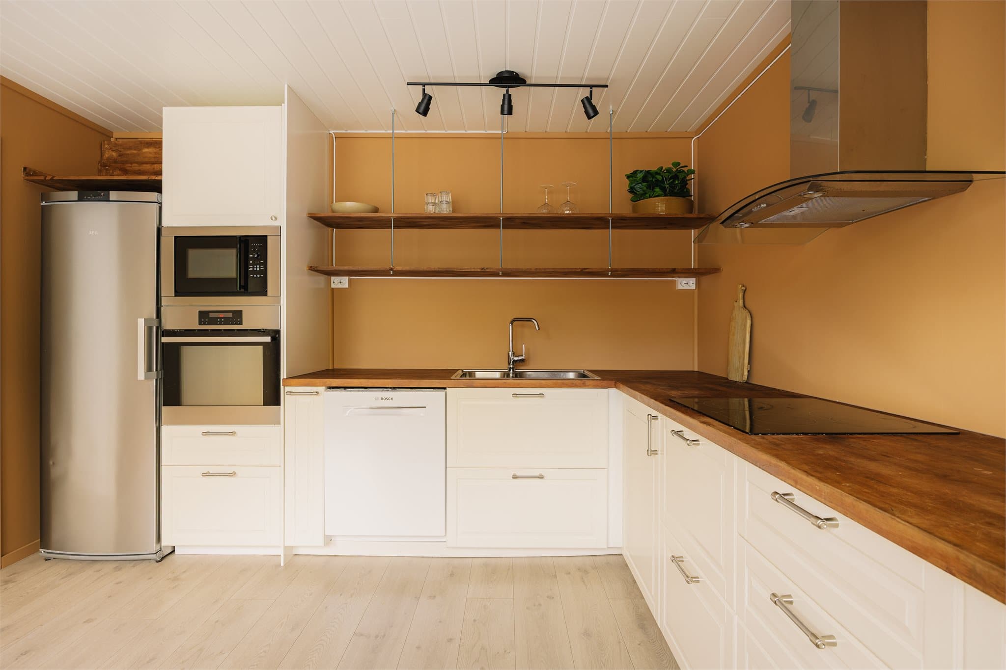 Kjøkkenet er innredet med IKEA kjøkken fra 2016 med profilerte, fabrikklakkerte fronter som gir et klassisk uttrykk. Benkeplate i treverk med nedfelt kum i rustfritt stål og malte flater på vegg over benkeplate.