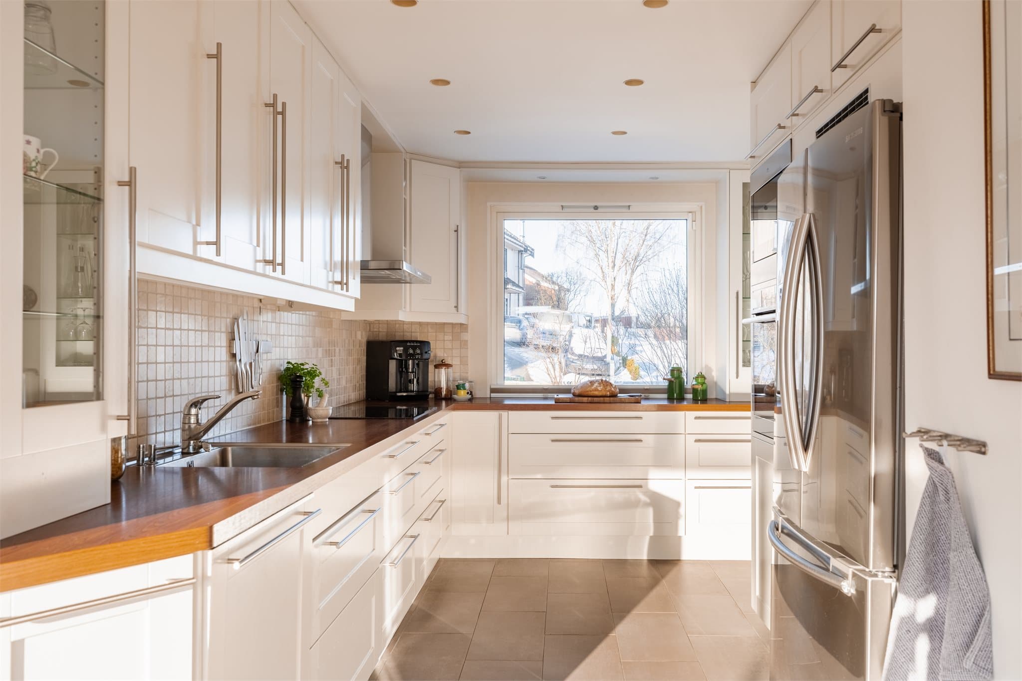 Kjøkkenet har en praktisk utforming med gode arbeidsflater og moderne hvitevarer.