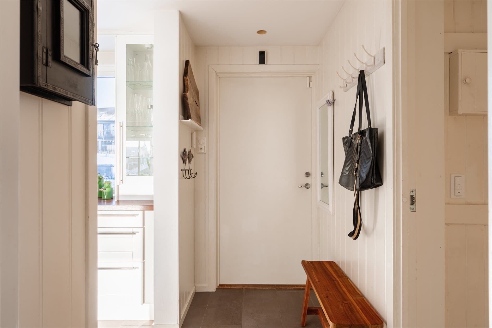 Romslig entré med flislagt gulv.