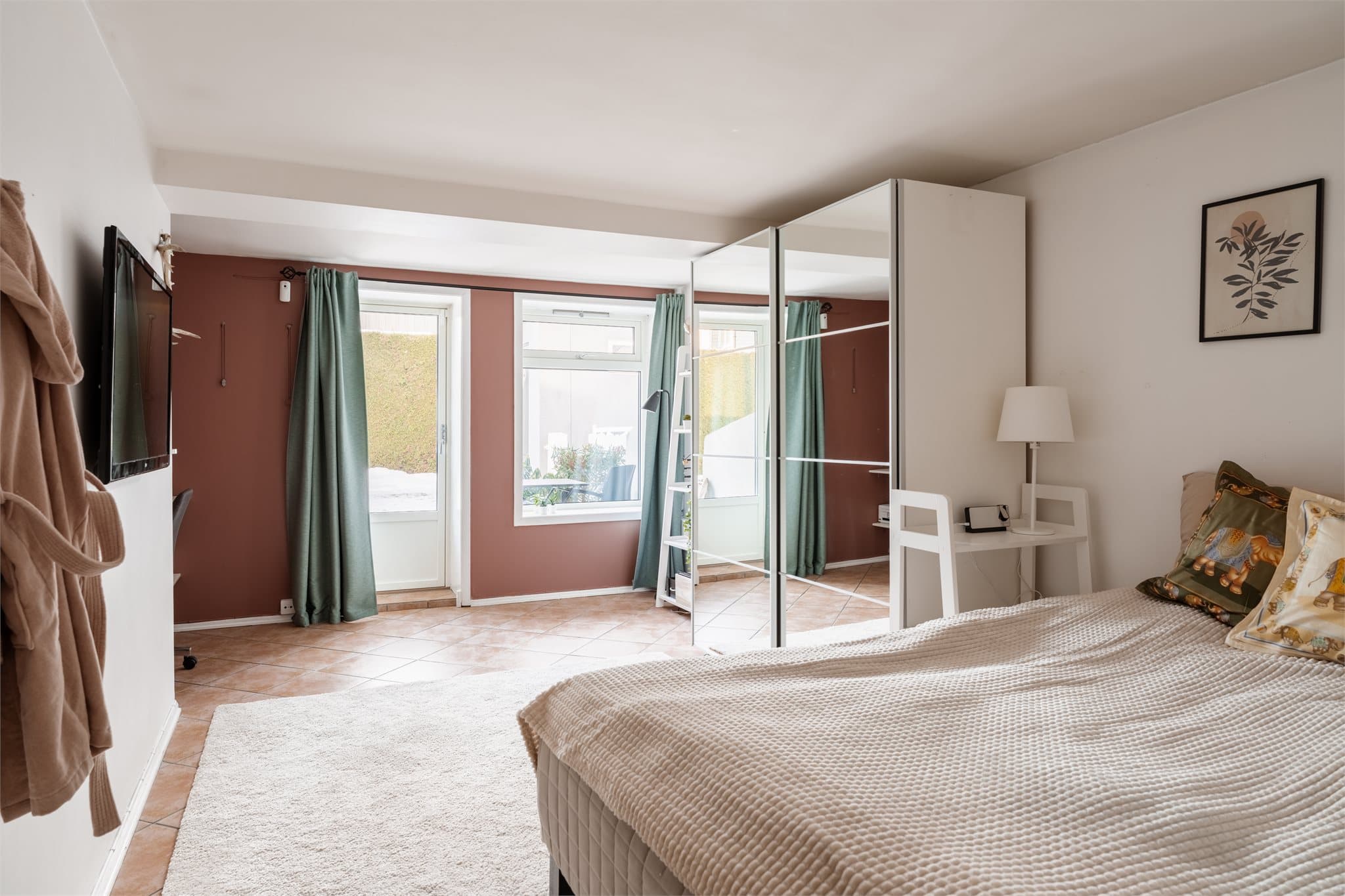 Et romslig soverom med plass til både seng og en liten arbeidsplass.