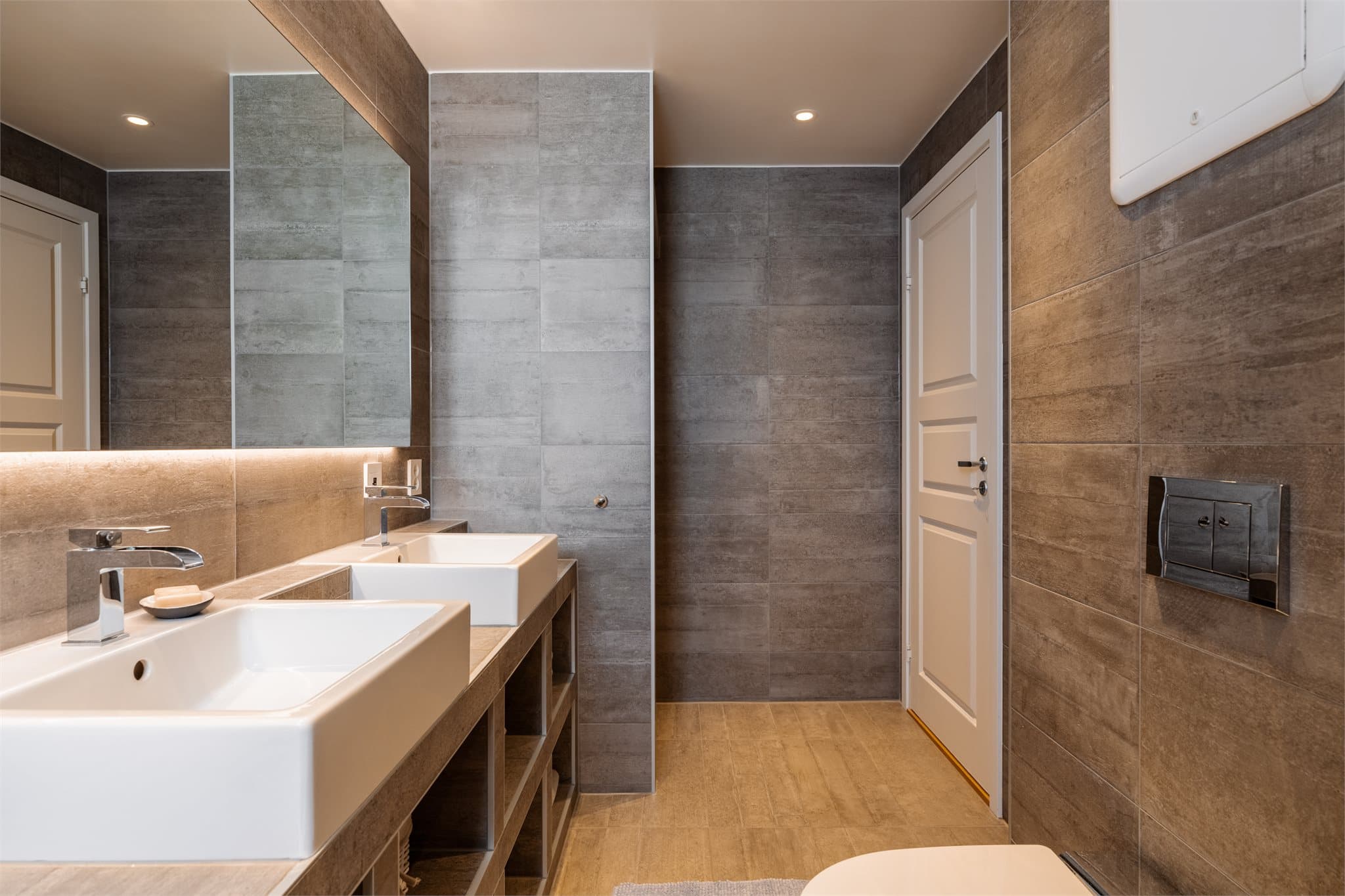 Her er det varmekabler i gulvet, downlights i taket og et veggmontert toalett med spylefunksjon.