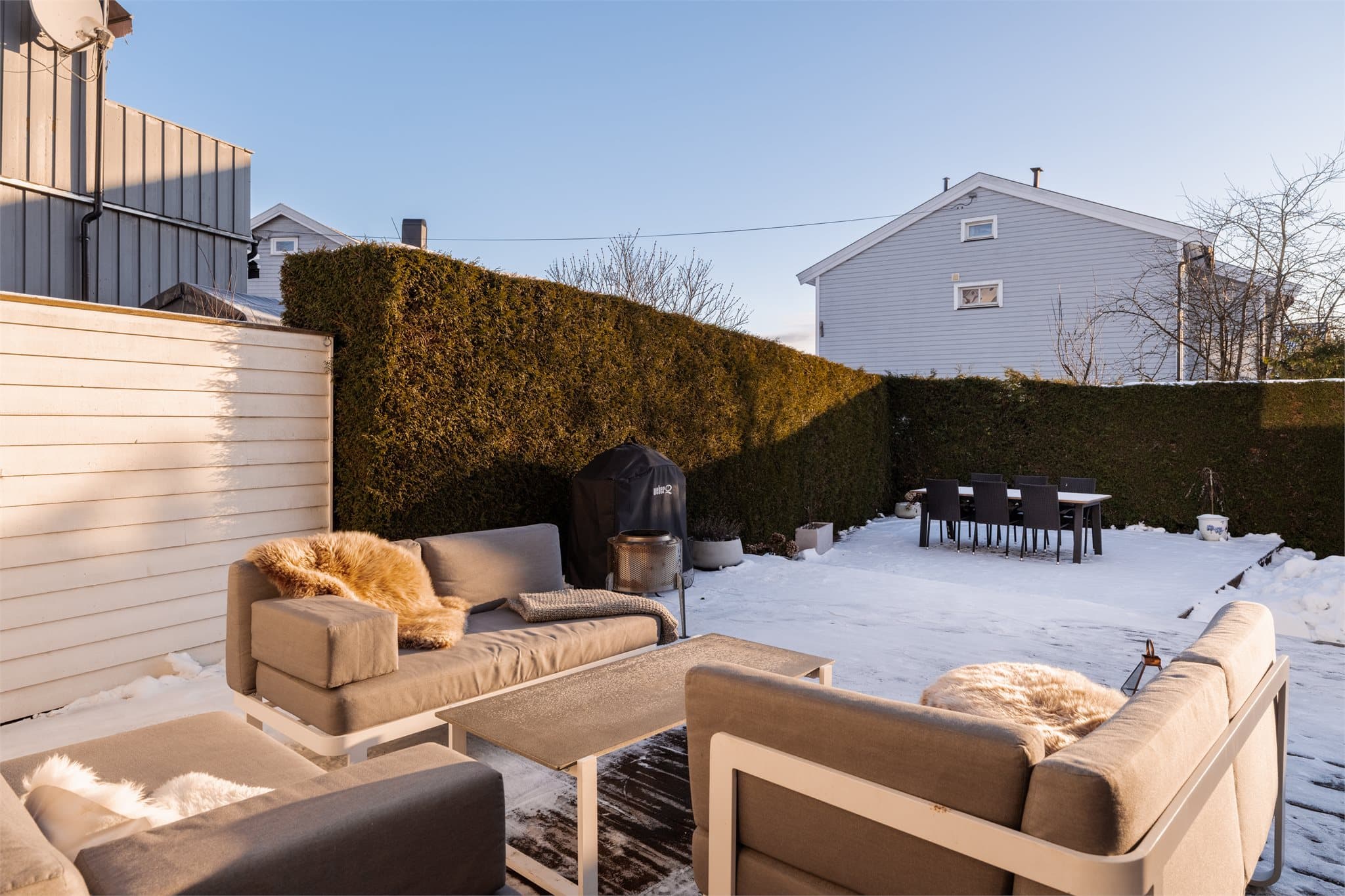 Uteplassen er pent opparbeidet og rammet inn av hekk som gir god skjerming.