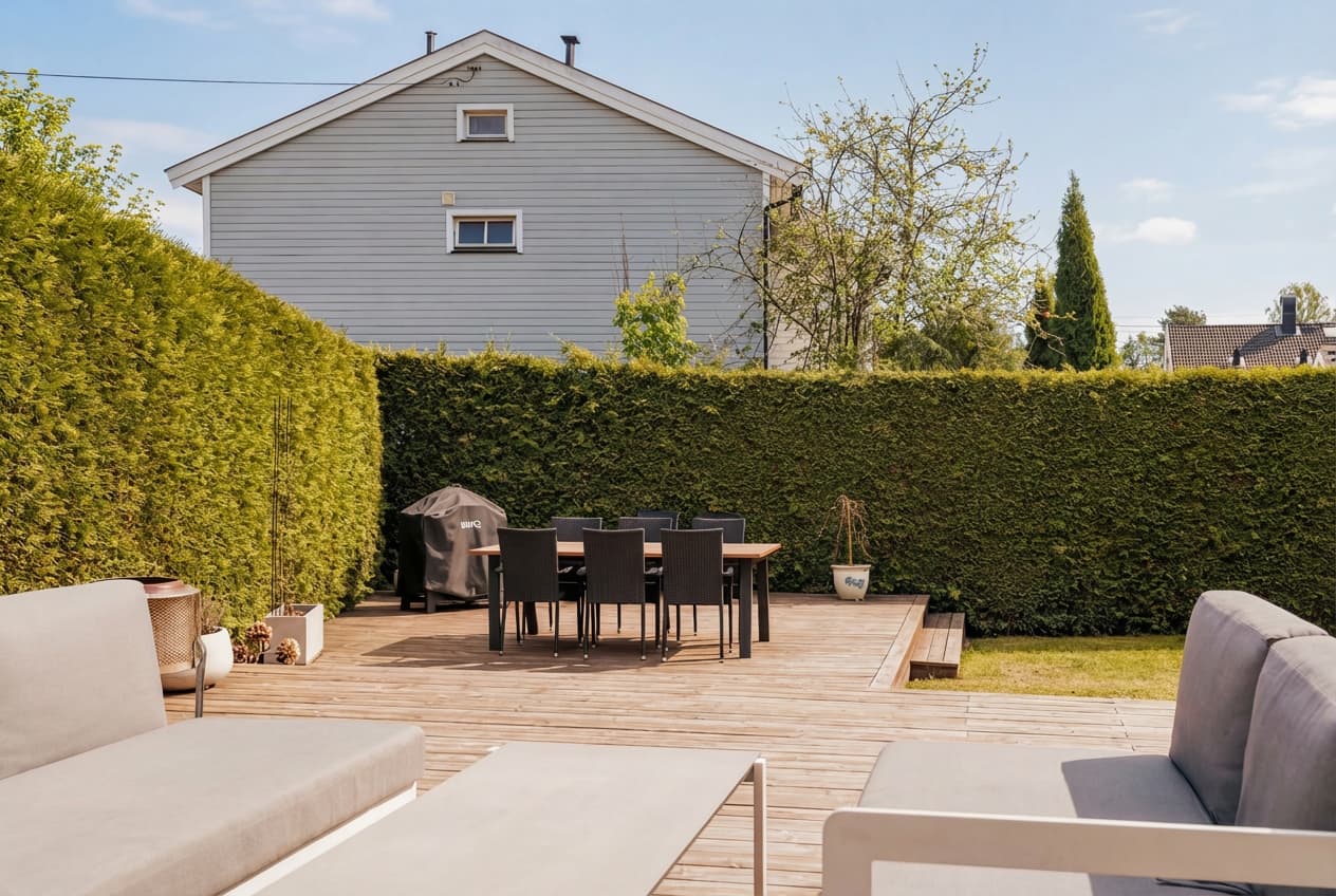 Uteplassen er pent opparbeidet og rammet inn av hekk som gir god skjerming.