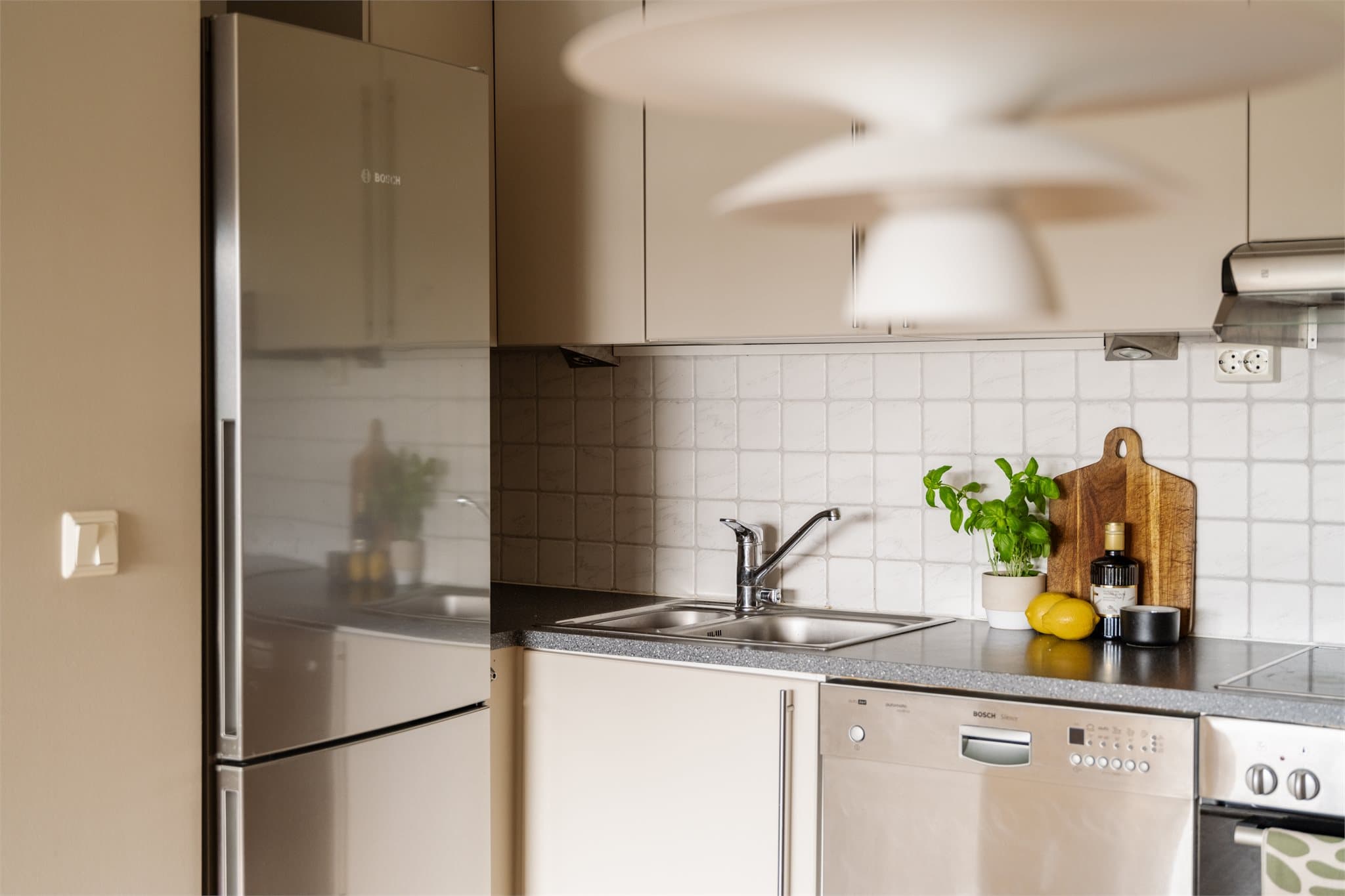 Praktisk kjøkken med oppvaskkum i stål og kjøl/fryseskap.
