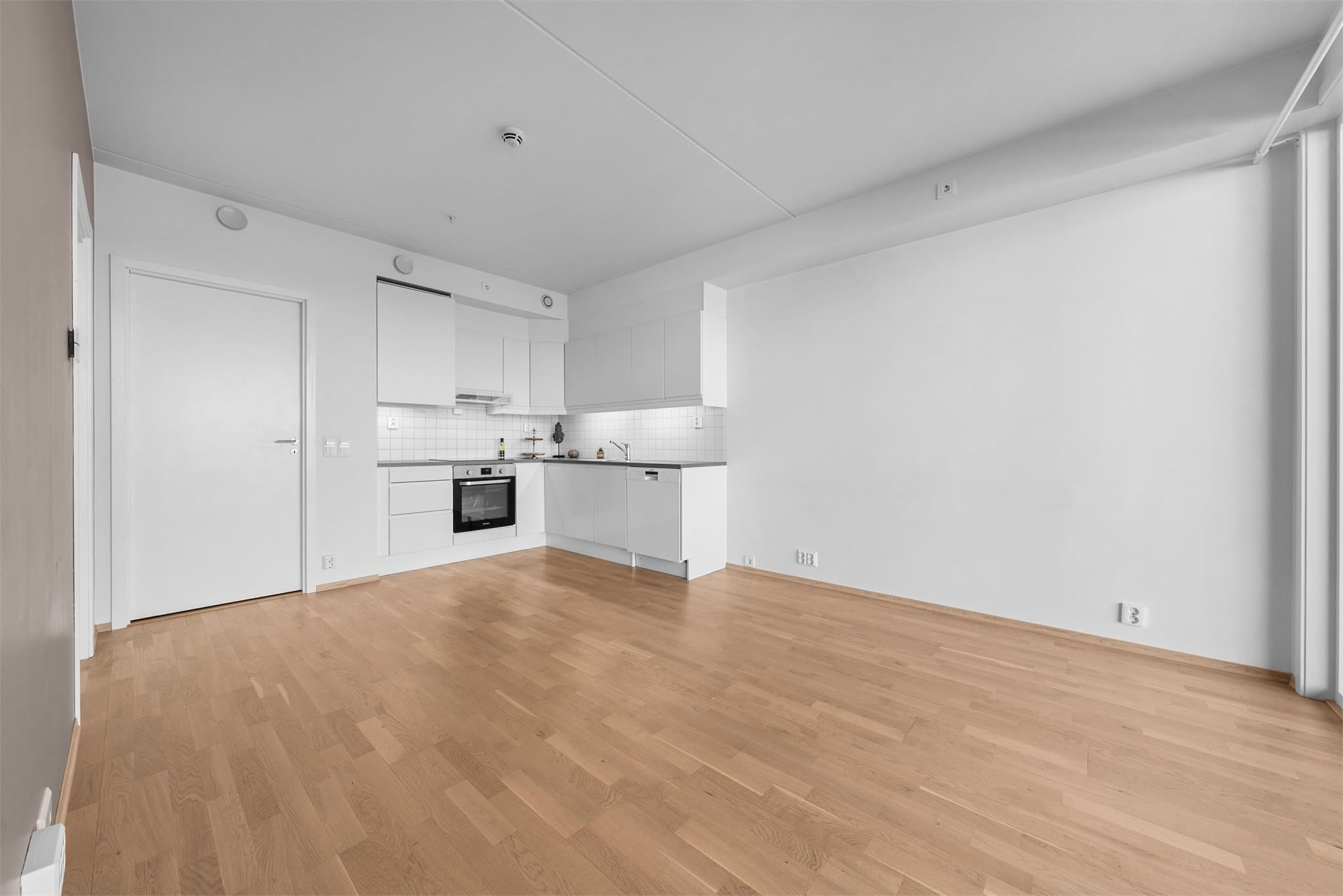 Oppholdsrommet byr på flere møbleringsmuligheter, med plass til spisegruppe og sofa med tilhørende møblement.