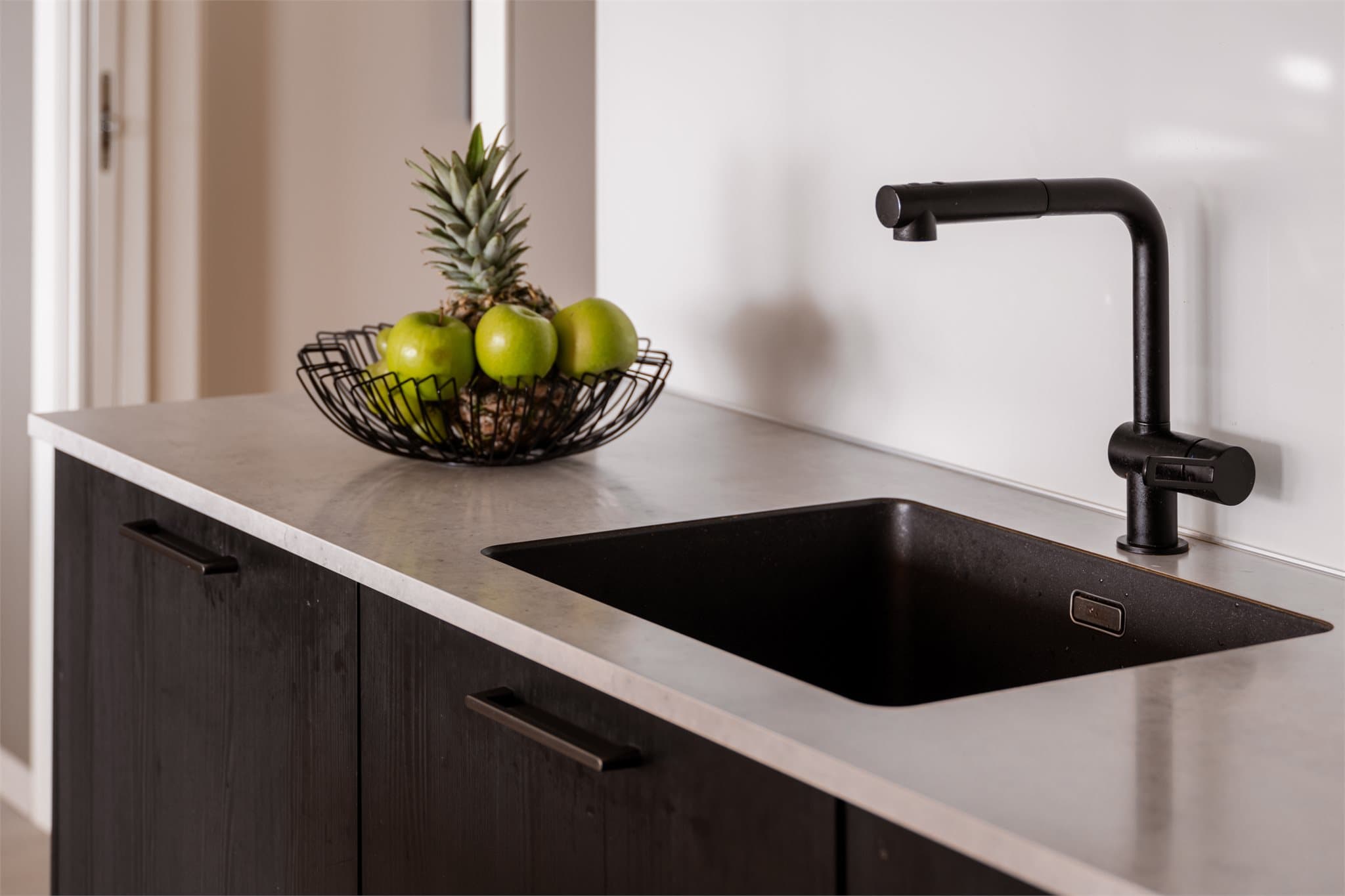 Detaljer som nedfelt vask og moderne armatur understreker den gjennomførte stilen.