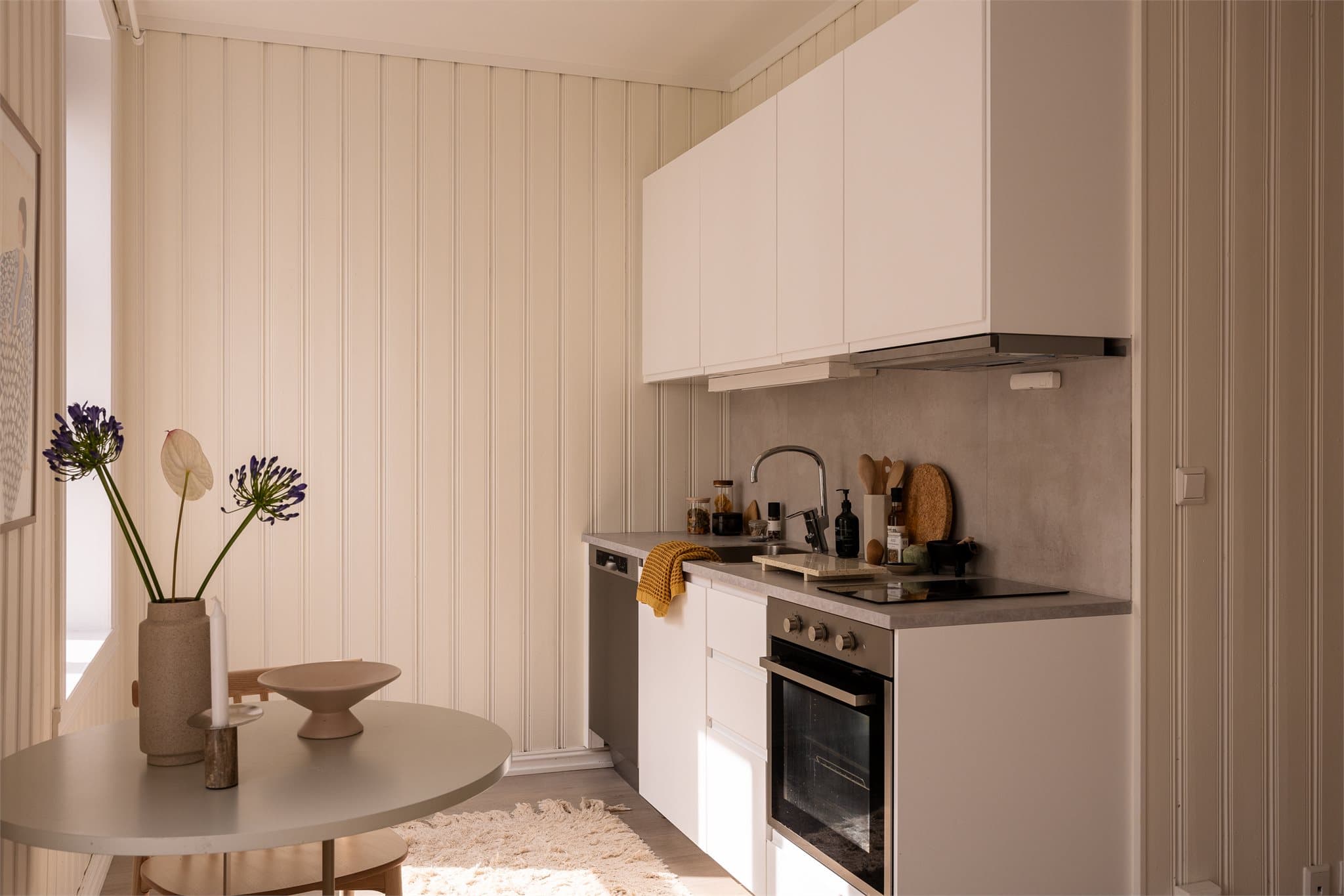 Kjøkken fra Ikea med glatt innredning. Integrert komfyr, oppvaskmaskin (smal type) og plass til frittstående kjøleskap/fryseskap.