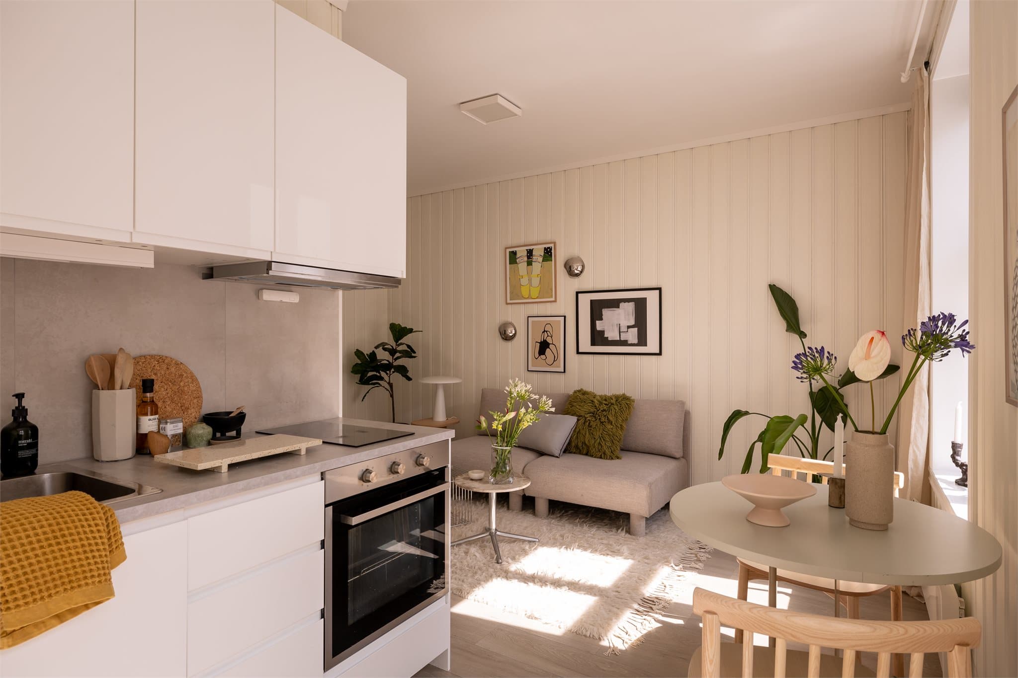 Kjøkken og stue ligger i åpen løsning, men føles likevel som to gode soner da kjøkkenet er trukket inn i eget hjørne.