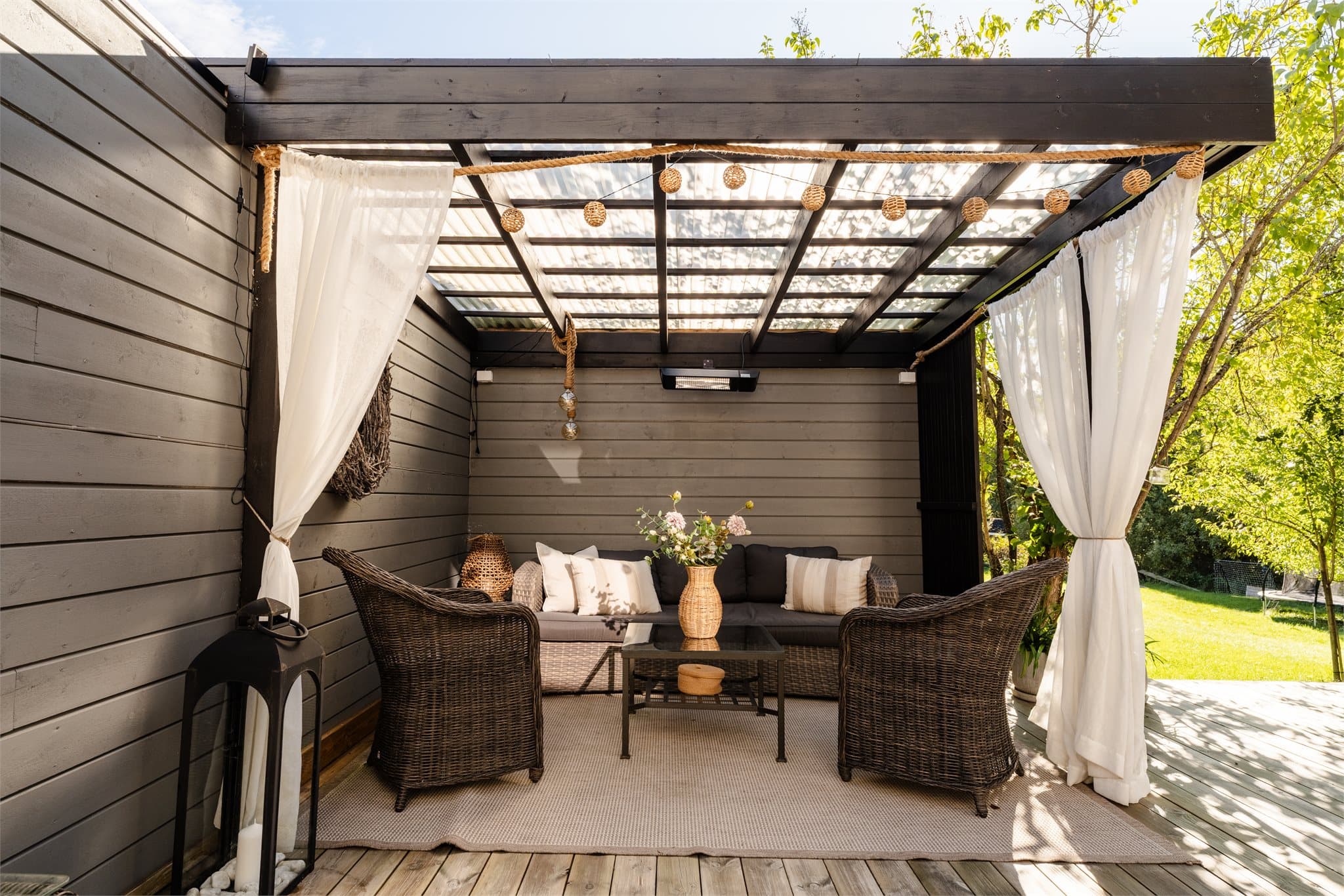 Pergolaen er utstyrt med tak, gardiner og terrassevarmer for kjøligere kvelder.