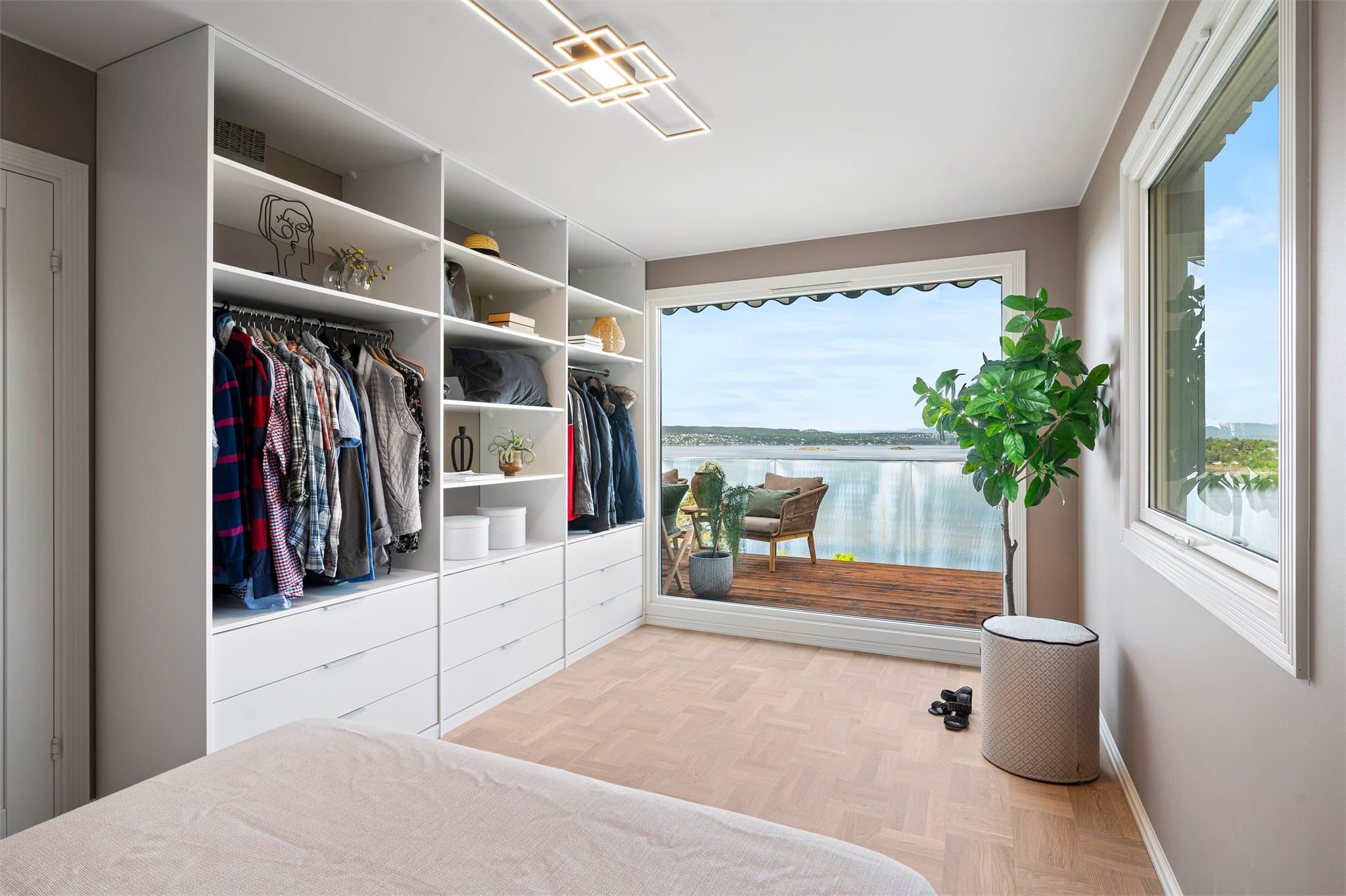 Det er også en stor, åpen garderobeløsning med rikelig med skap- og hylleplass, som gir praktisk oppbevaring.