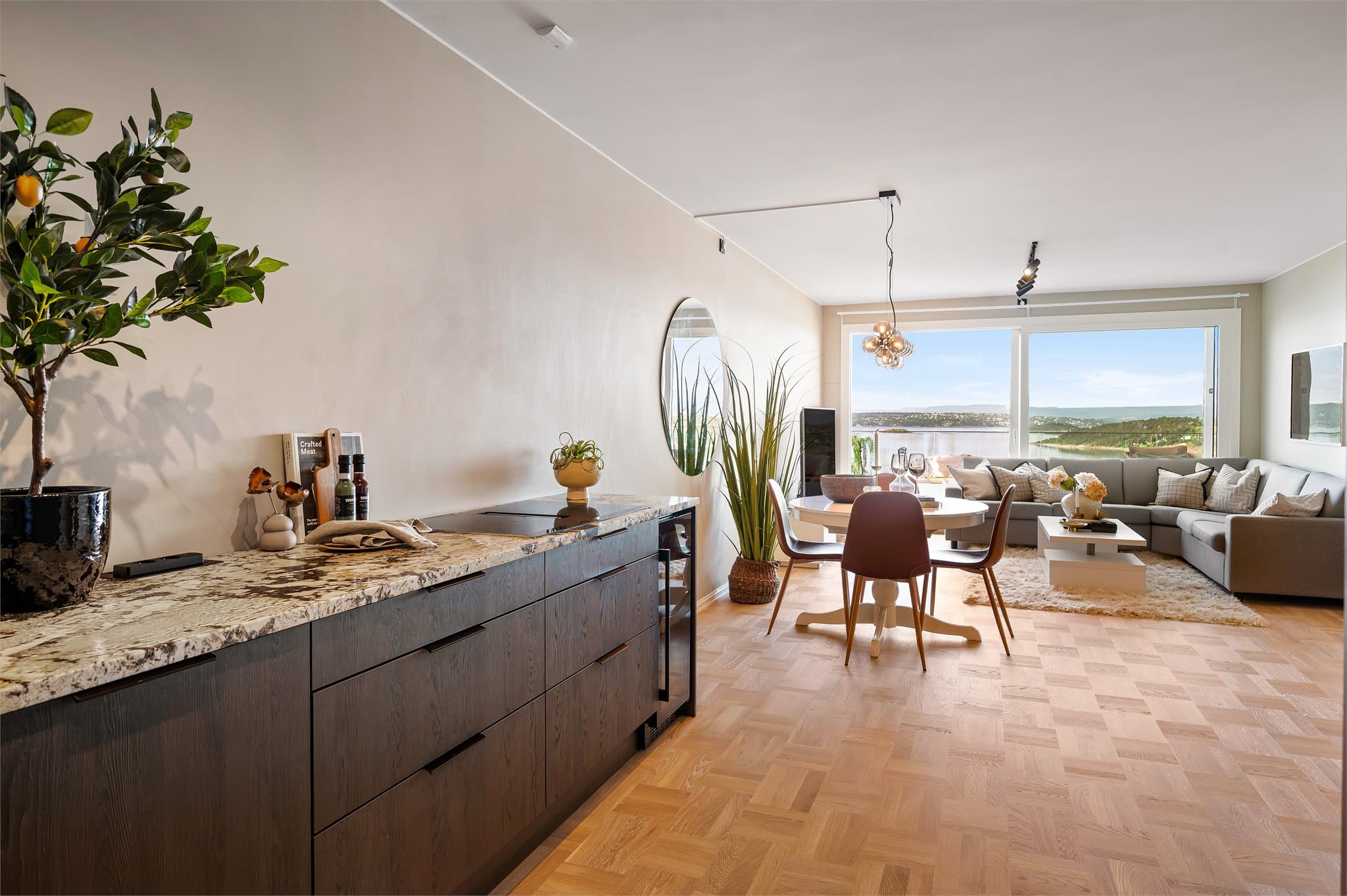 Kjøkkenet har glatte, mørke skapfronter som gir et elegant og tidløst uttrykk. Benkeplatenen marmor tilfører en eksklusiv følelse.