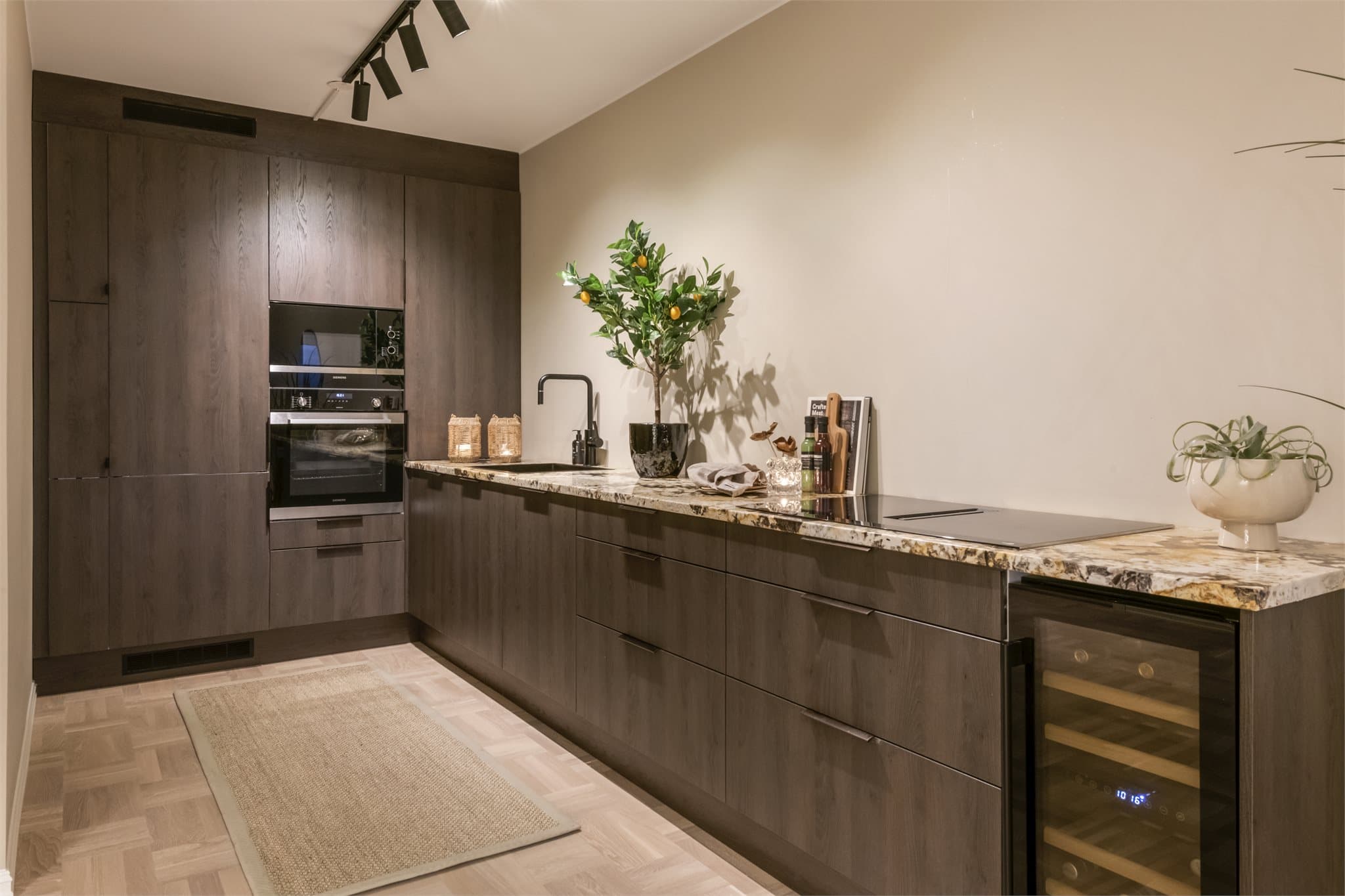 Kjøkkensonen defineres av en langstrakt innredning, som ivaretar den åpne atmosfæren i rommet.