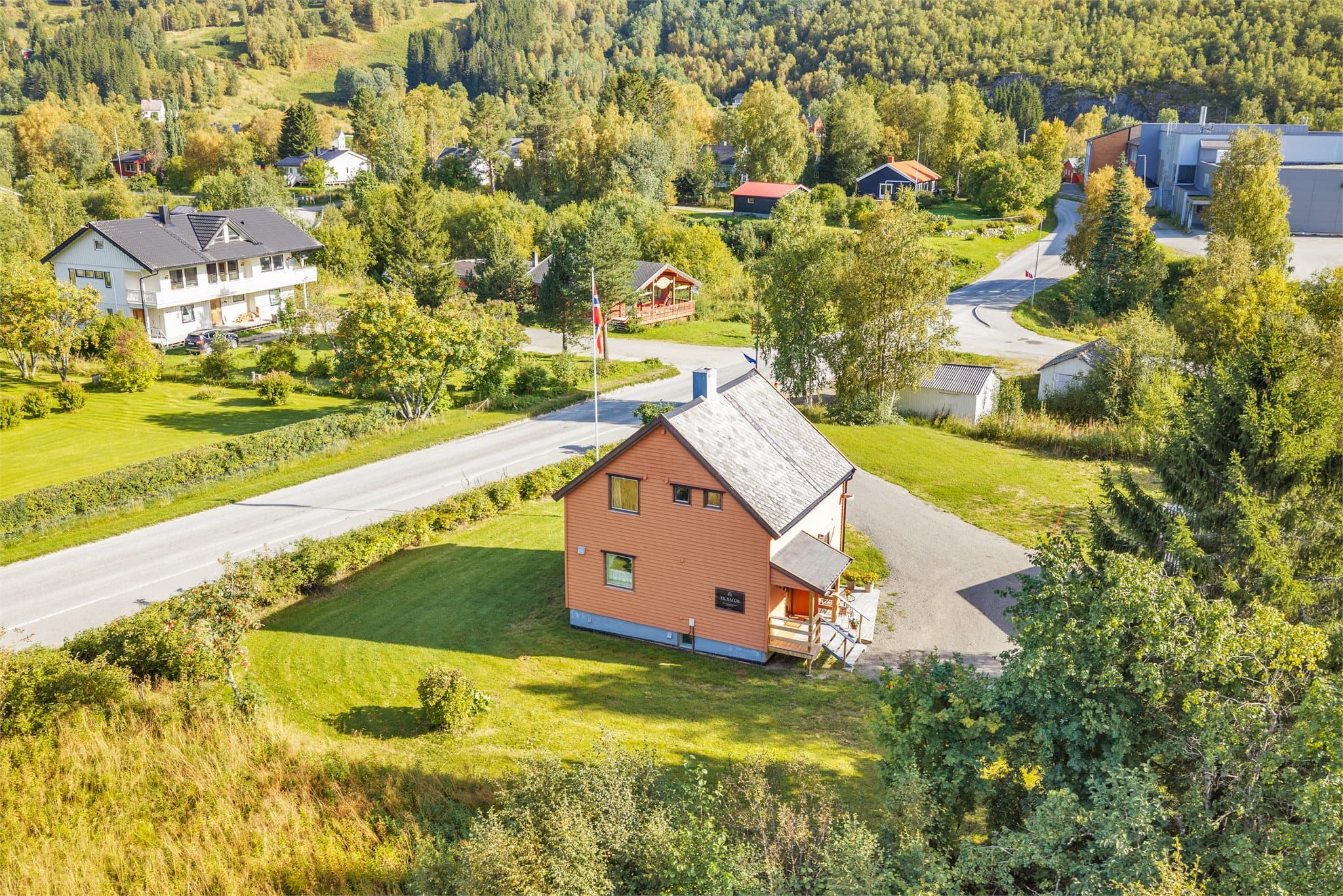 Tomta er flat og planert med plen og grusvei